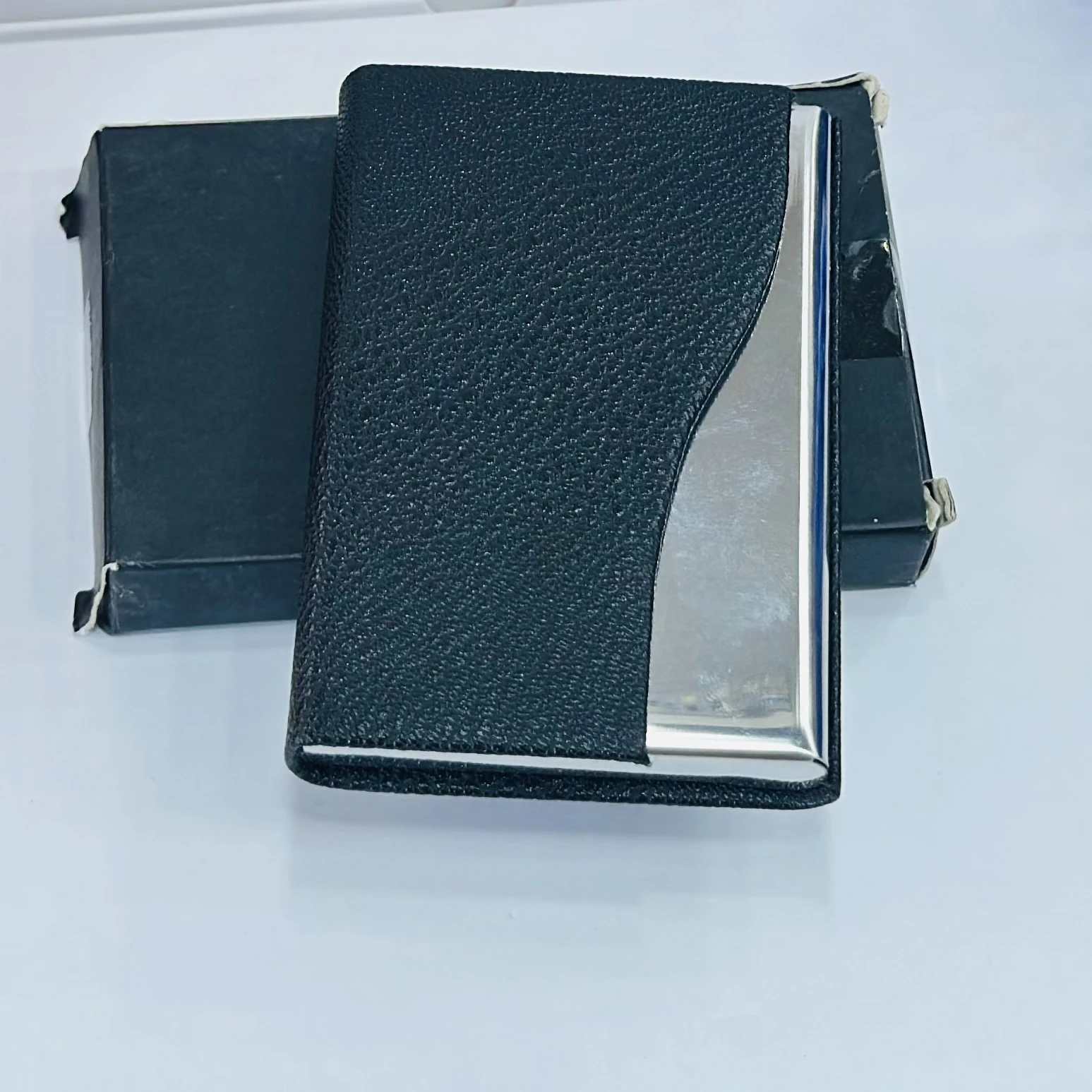 black faux leather and metal business card holder.