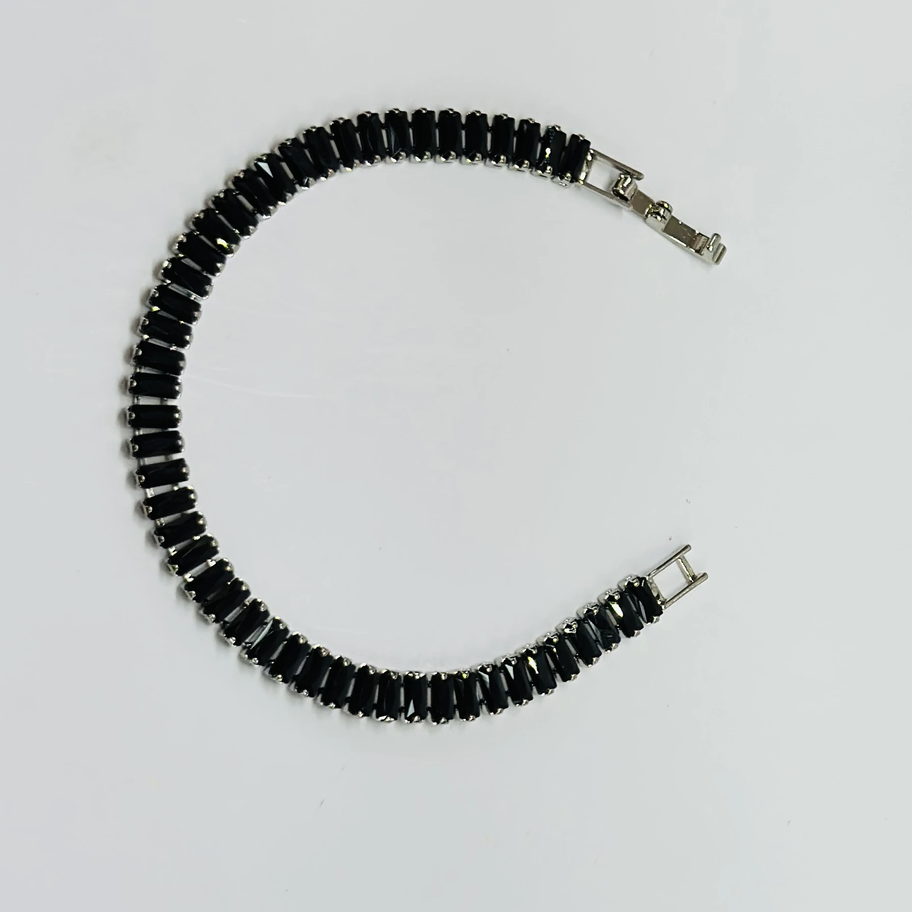 Gold plated black baguette tennis bracelet with artificial stones.