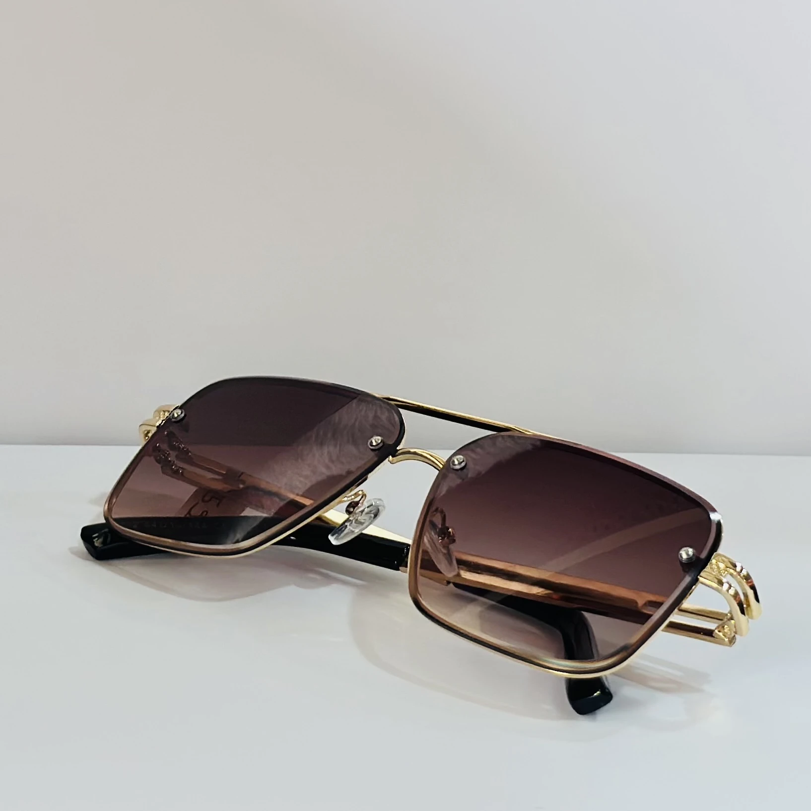 pair of Maybach-style sunglasses with gold-toned frames and brown gradient lenses.