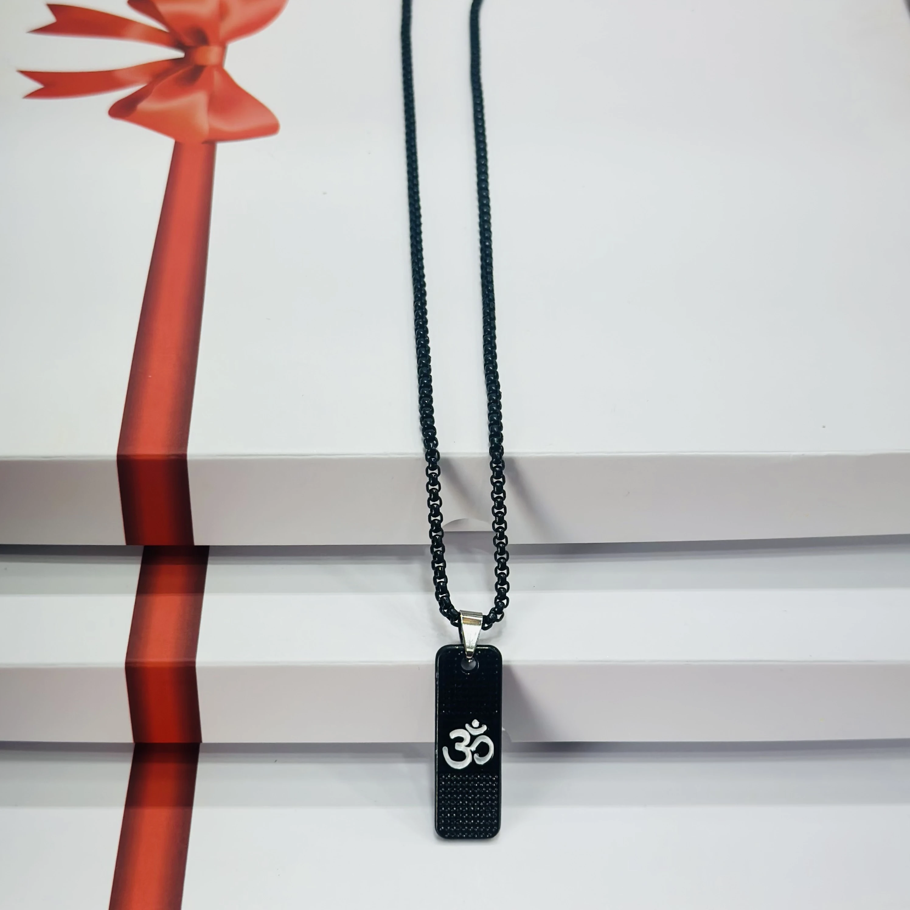 Black stainless steel pendant necklace with the white Om symbol.