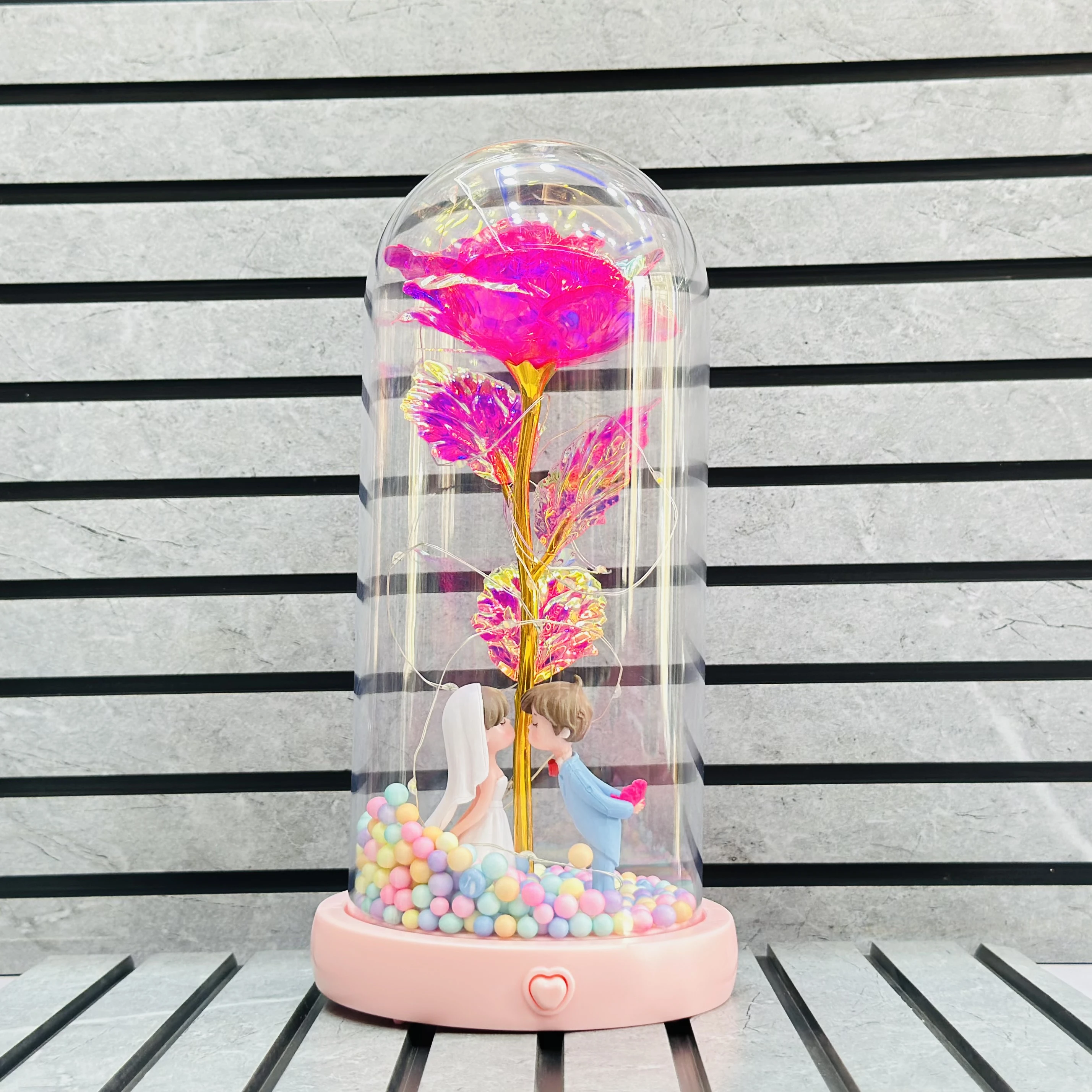 rose and a figurine of a couple inside a glass dome.(SKU-4LIPIQ)