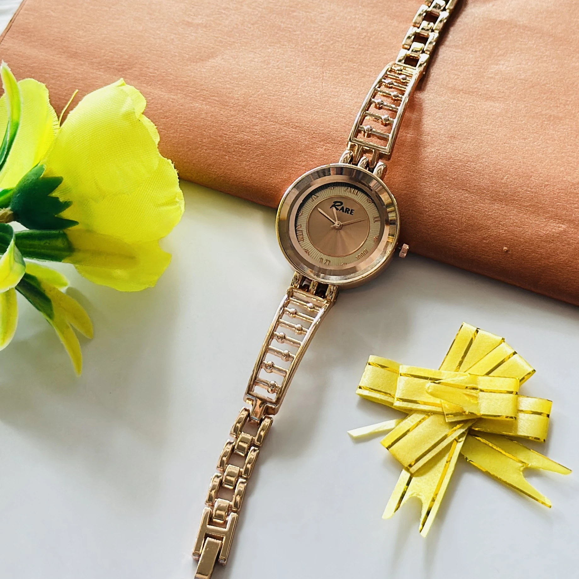 Raga women's rose gold analog wristwatch with a unique bracelet design