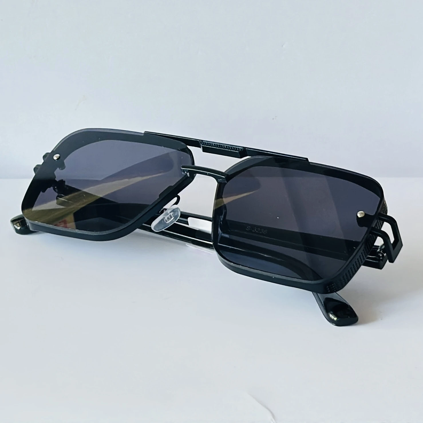 Black sunglasses feature a square frame