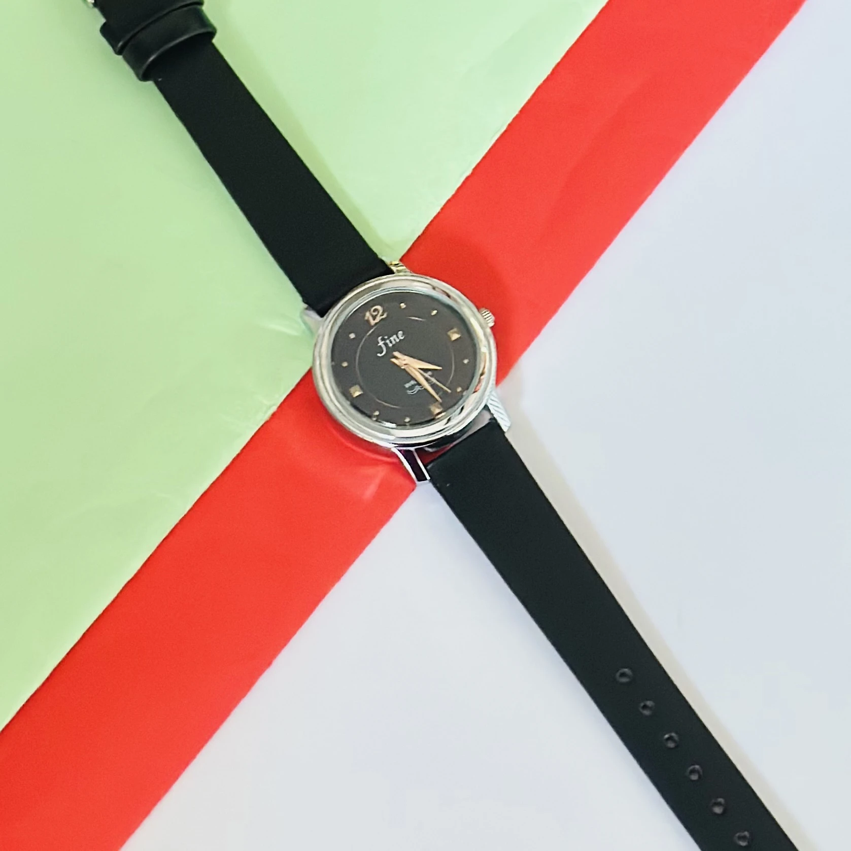 Black analog watch with a black strap.
