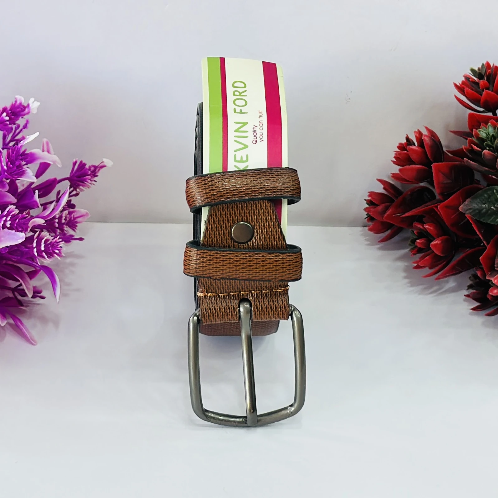 Brown leather belt with a pin buckle.