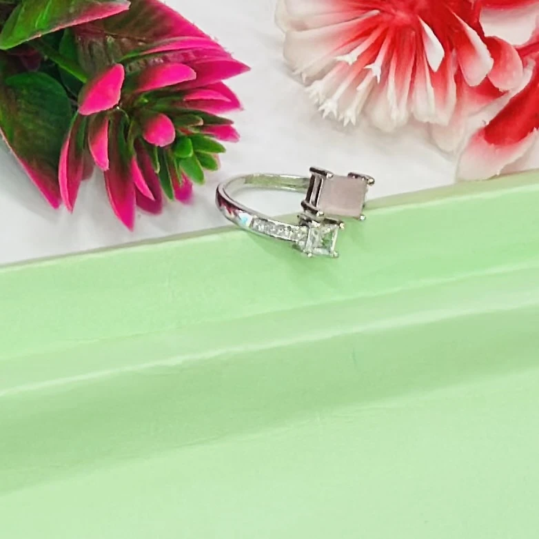 silver-toned ring featuring two prominent princess-cut stones