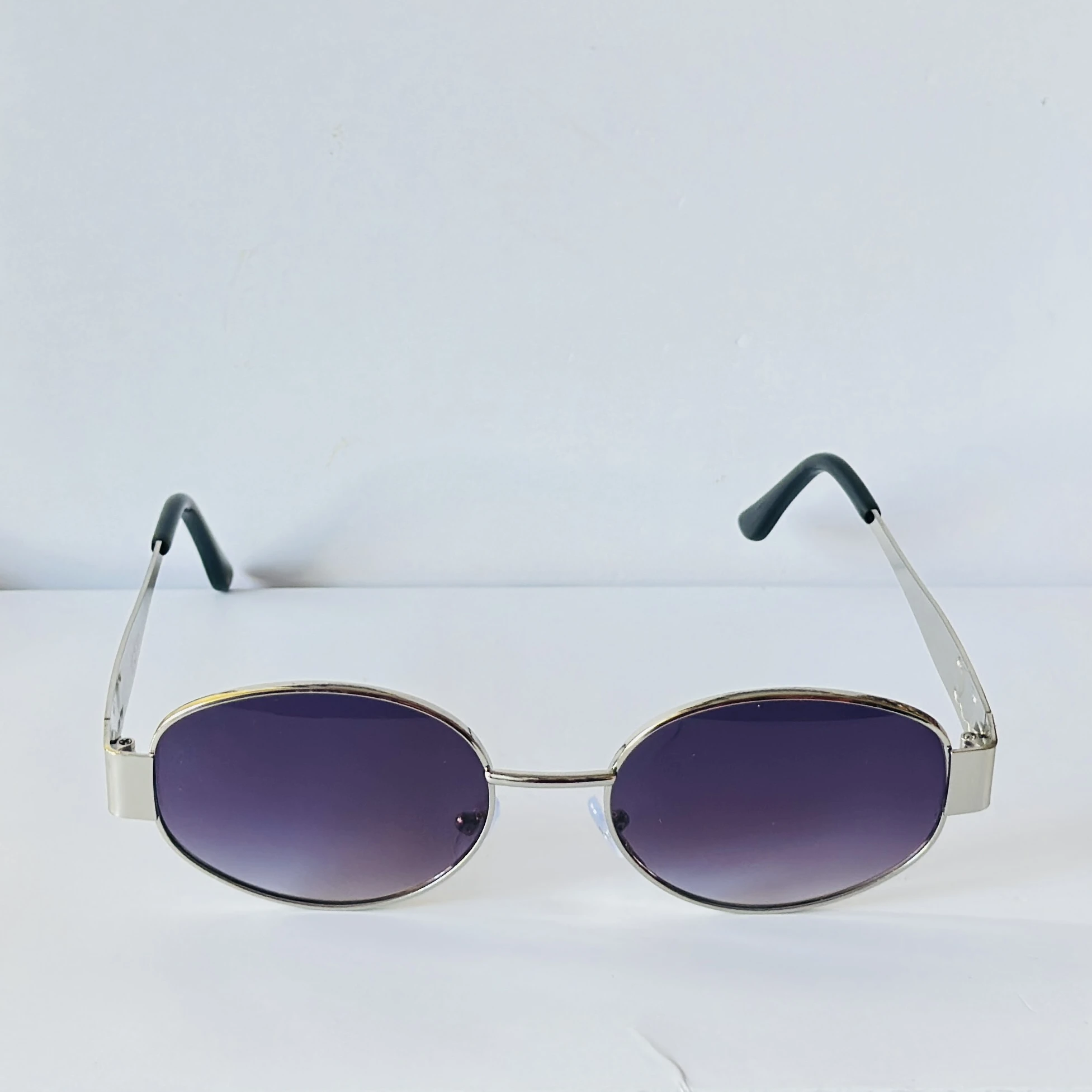 vintage-style metal sunglasses featuring purple oval lenses.