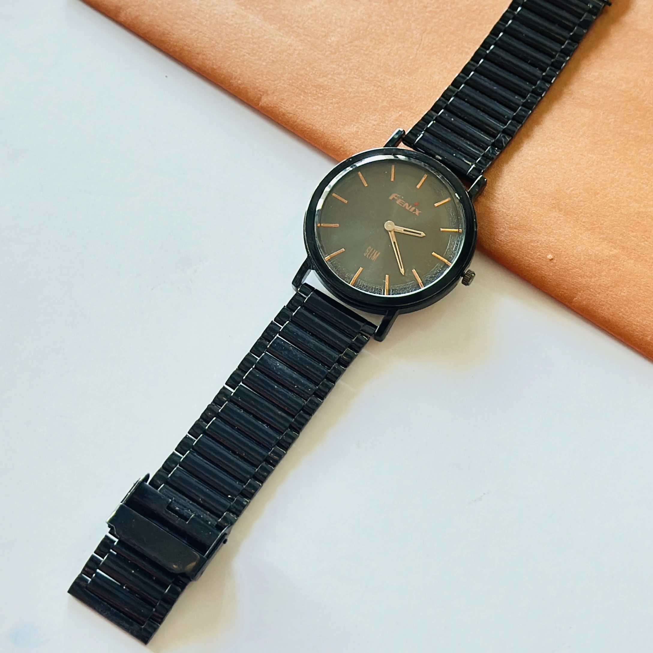 Fenix Slim black analog wristwatch with a matching metal band.