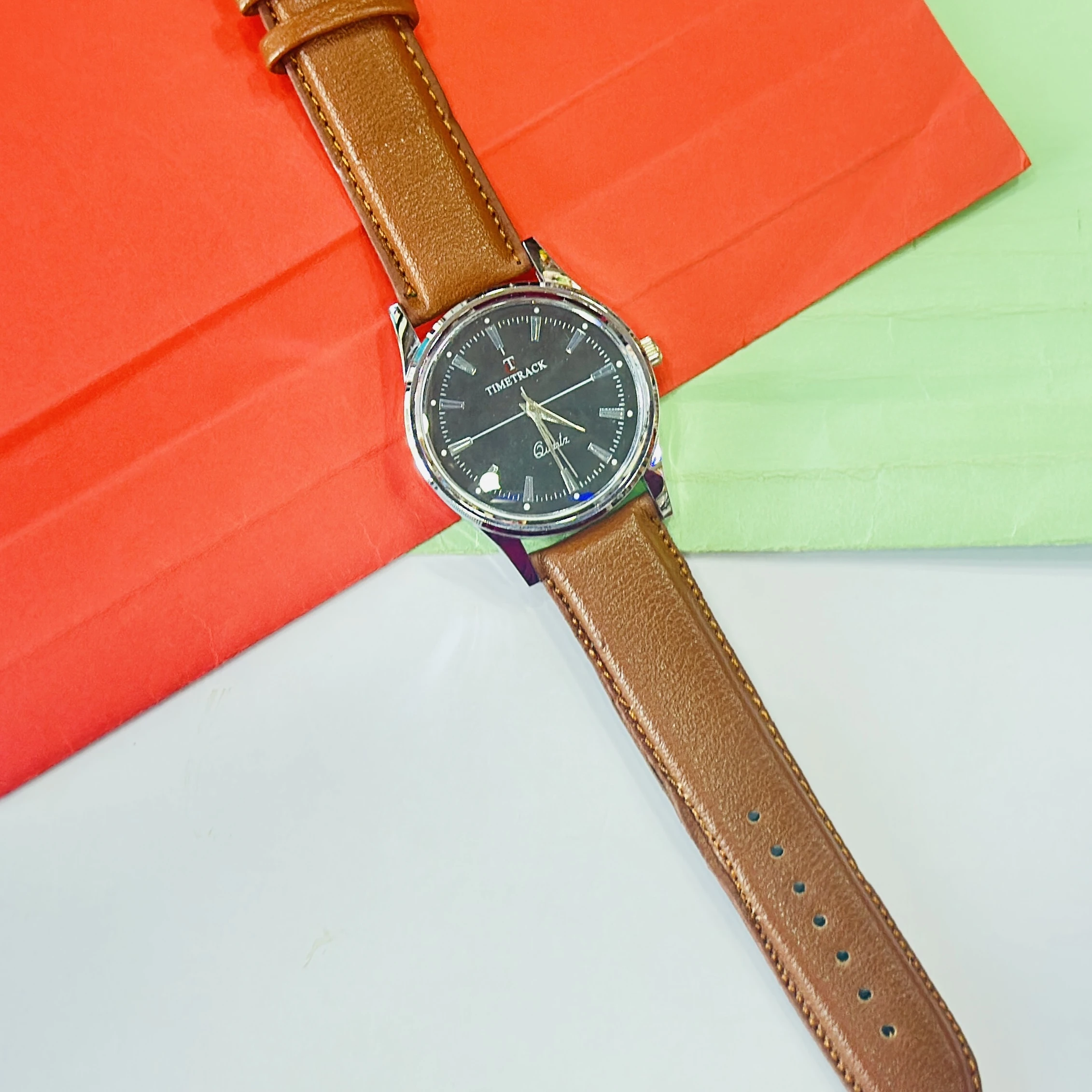 analog watch with a brown leather strap and a silver-toned case.