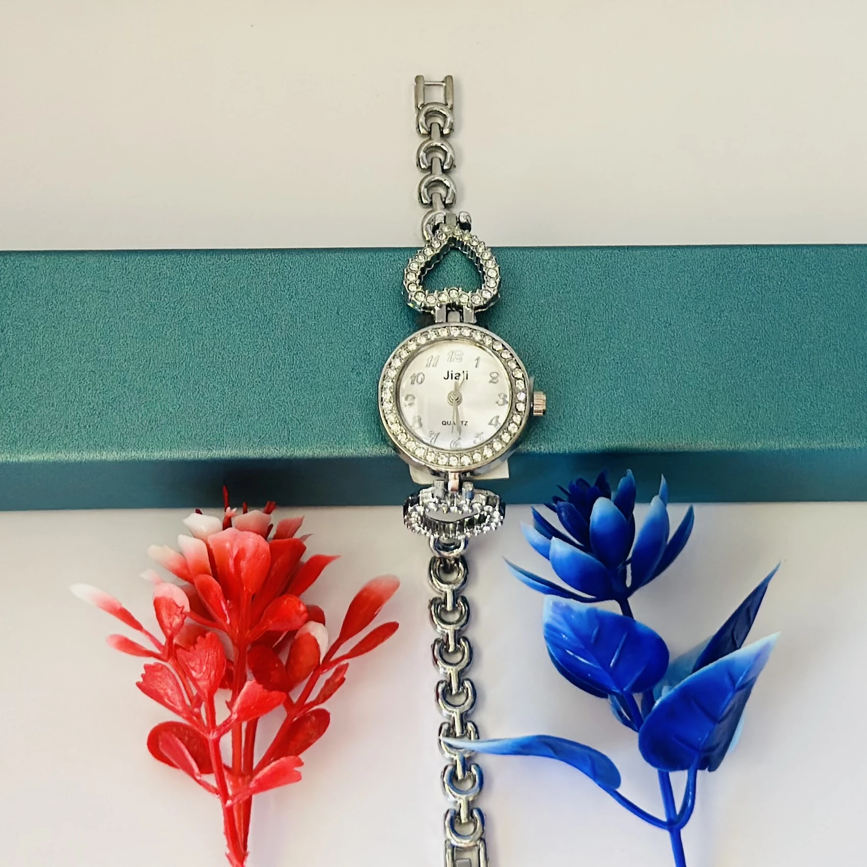 Women’s watch with a silver metal bracelet and crystal-studded bezel.