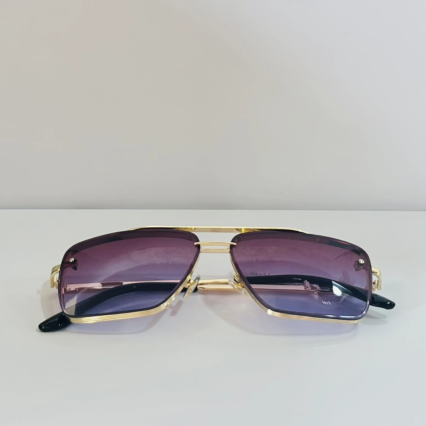 Sunglasses in a gold-tone metal frame with gradient lenses.