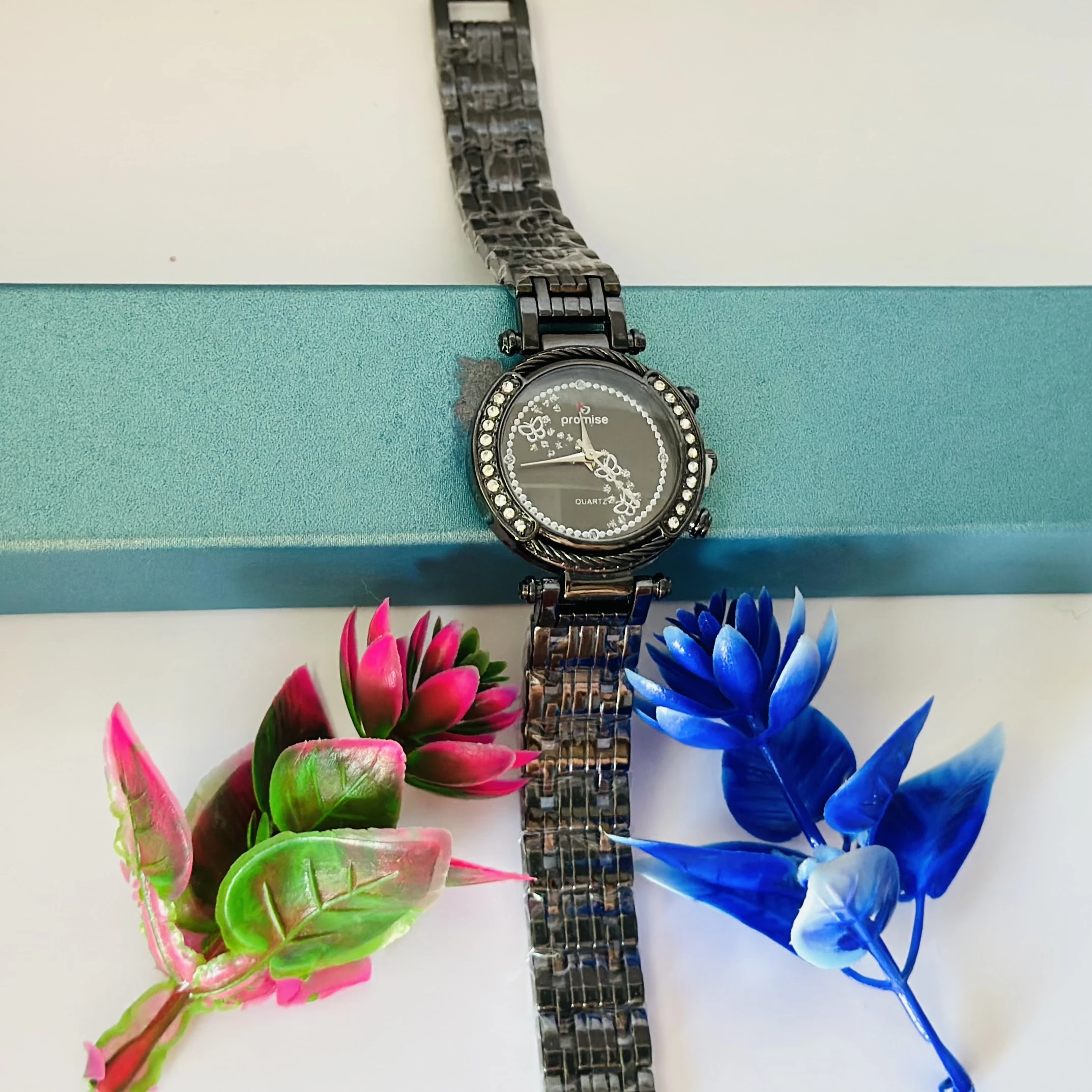 Quartz watch with a black metal band and a rhinestone-studded bezel.