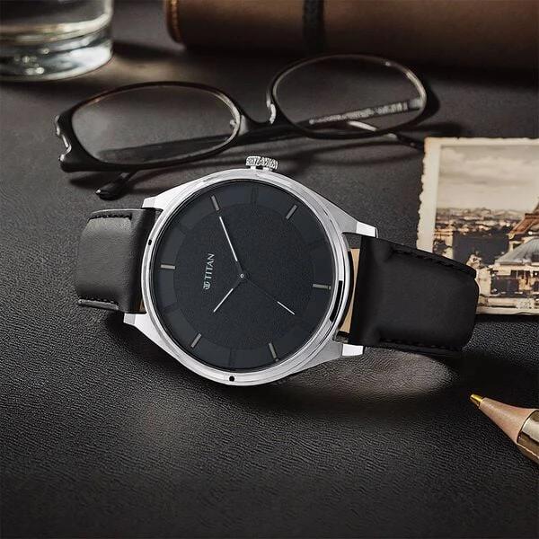 Titan analog wristwatch with a round black dial and a black leather strap