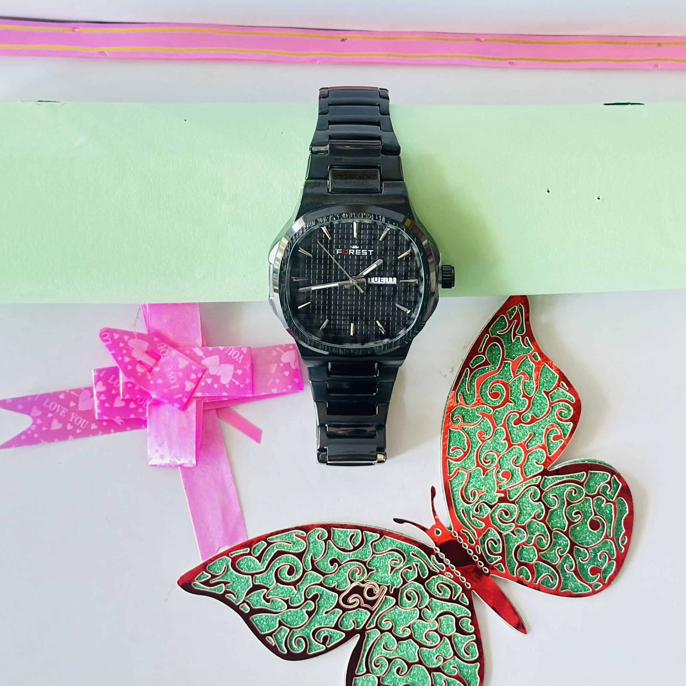 Forest brand analog watch features a black dial and a matching black metal strap.