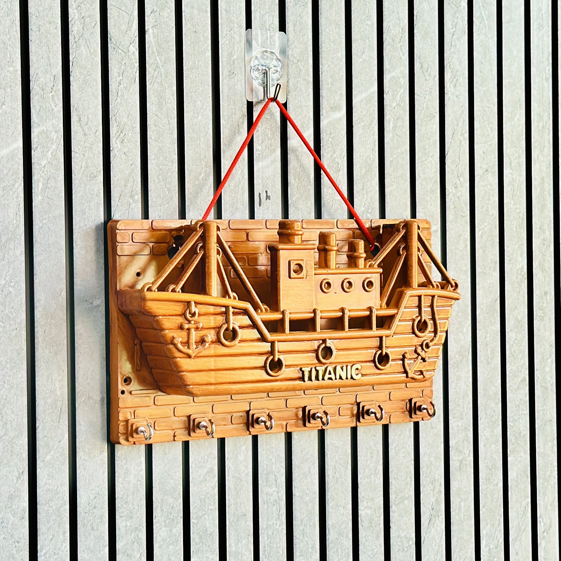 wooden wall-mounted key holder (BRYTZG )shaped like a ship labeled "TITANIC".
