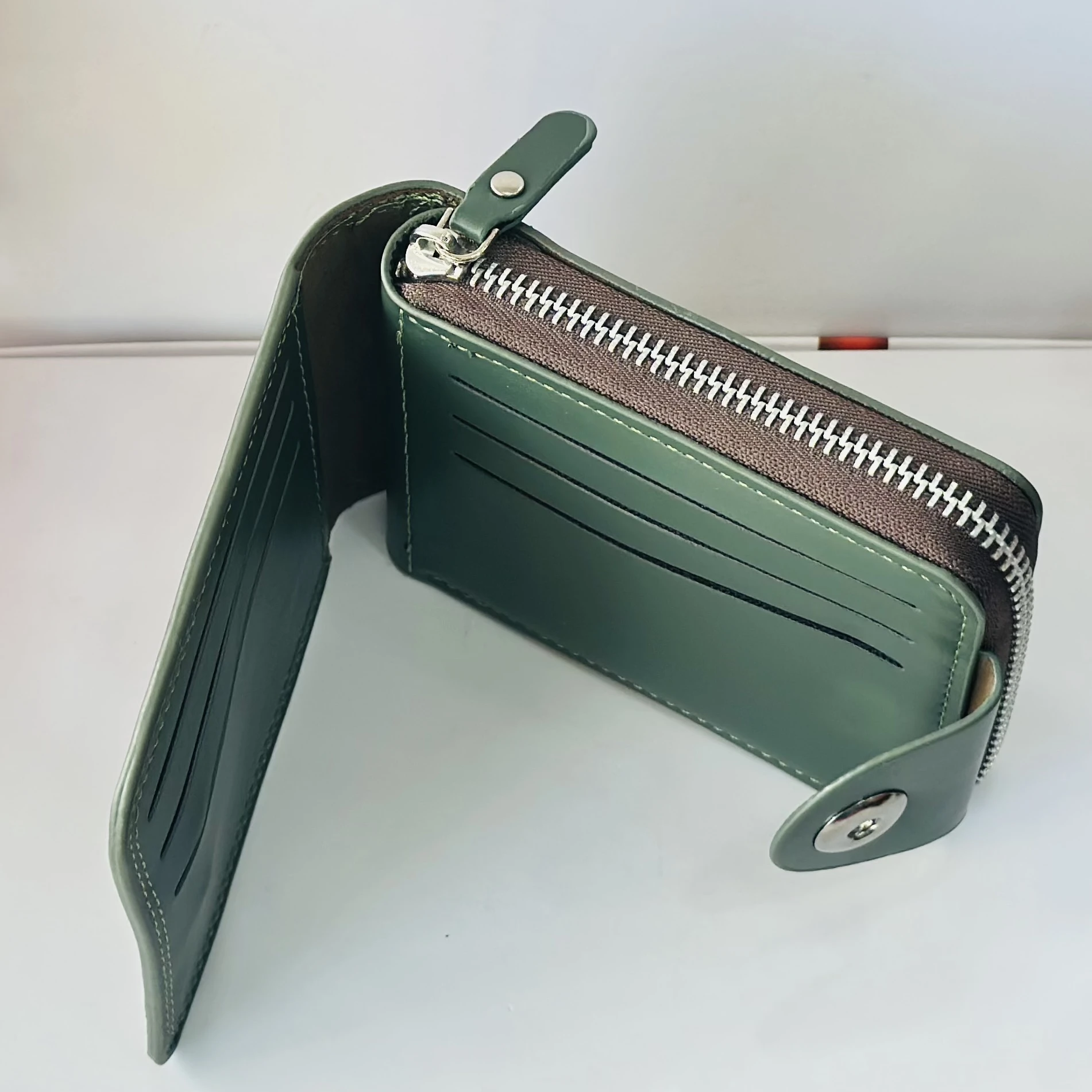 Balisi green leather wallet with a button closure.