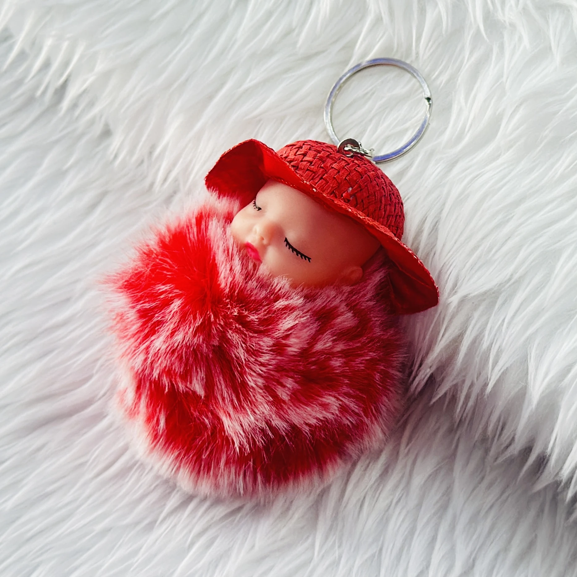 fluffy charm is a red and white SRG sleeping baby doll keychain