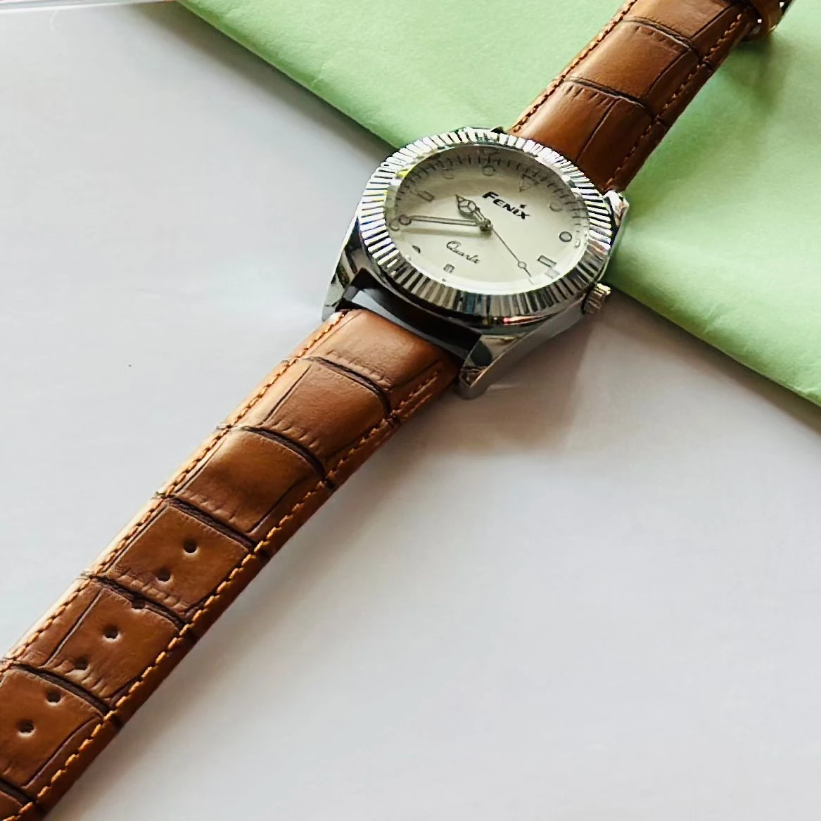 Round analog watch with a brown leather strap