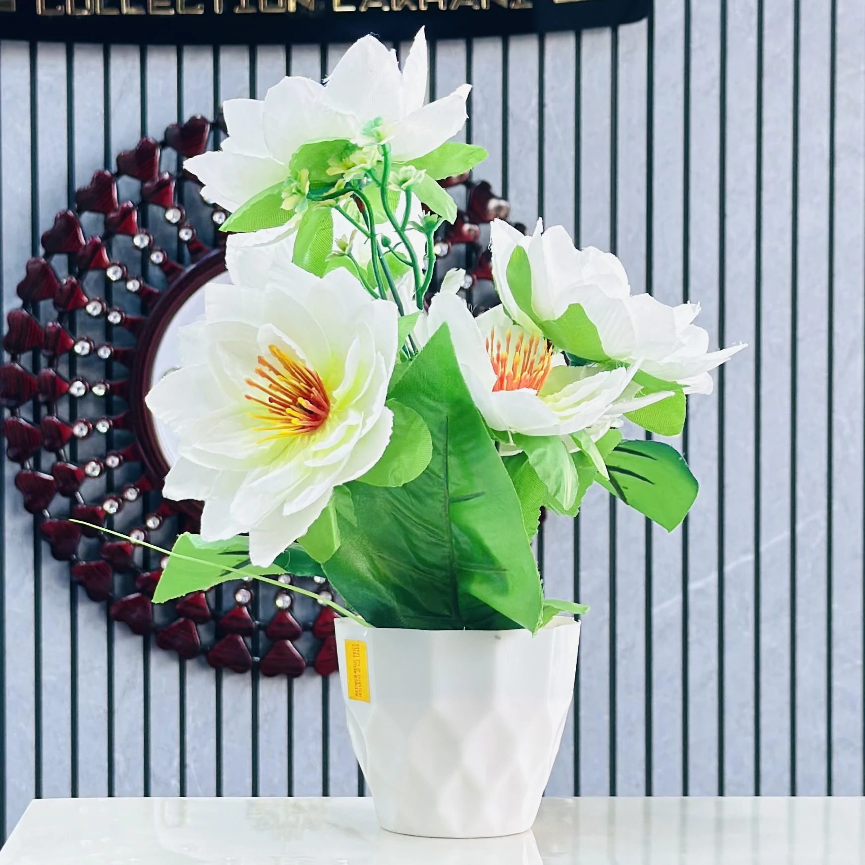 Flower arrangement in a white ceramic pot.