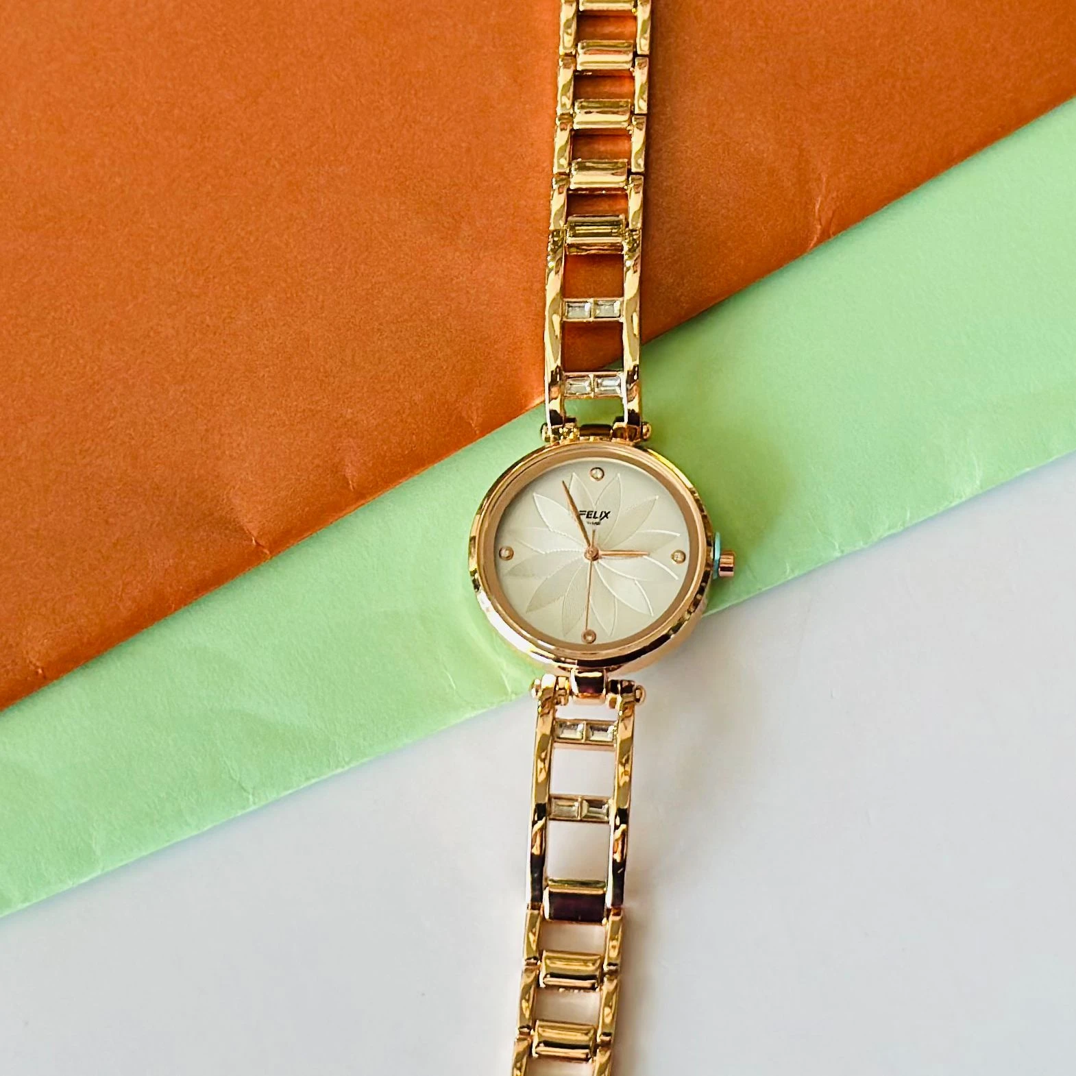 analog watch with a white dial and a rose gold metal strap