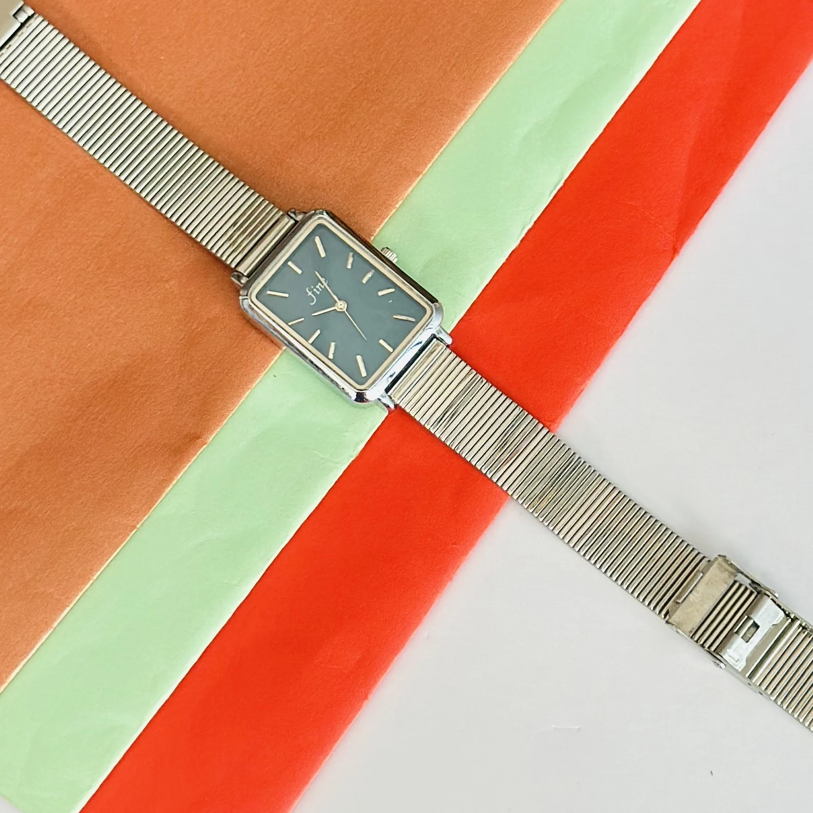 Rectangular Dial analog watch with a mesh strap.