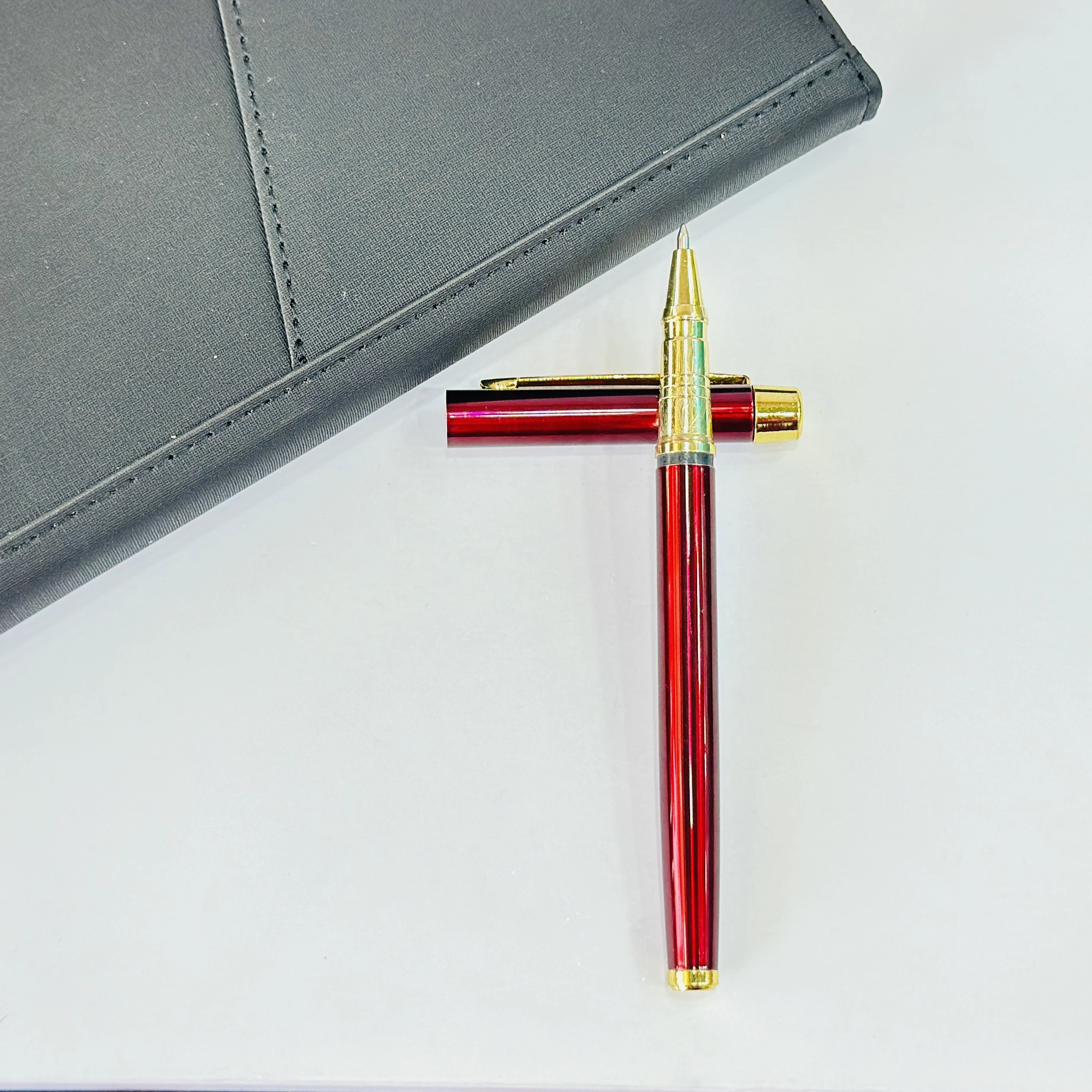 sleek maroon and gold metal rollerball pen