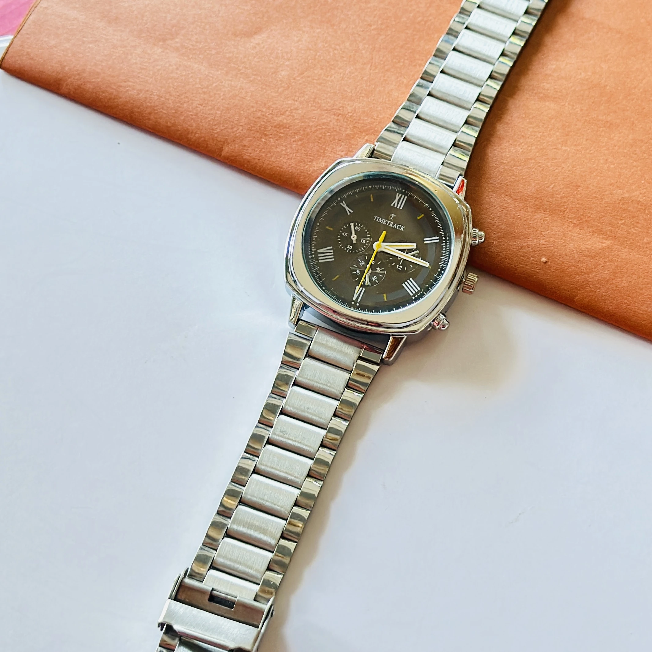 Timetrack brand analog watch with a square case and a stainless steel strap.