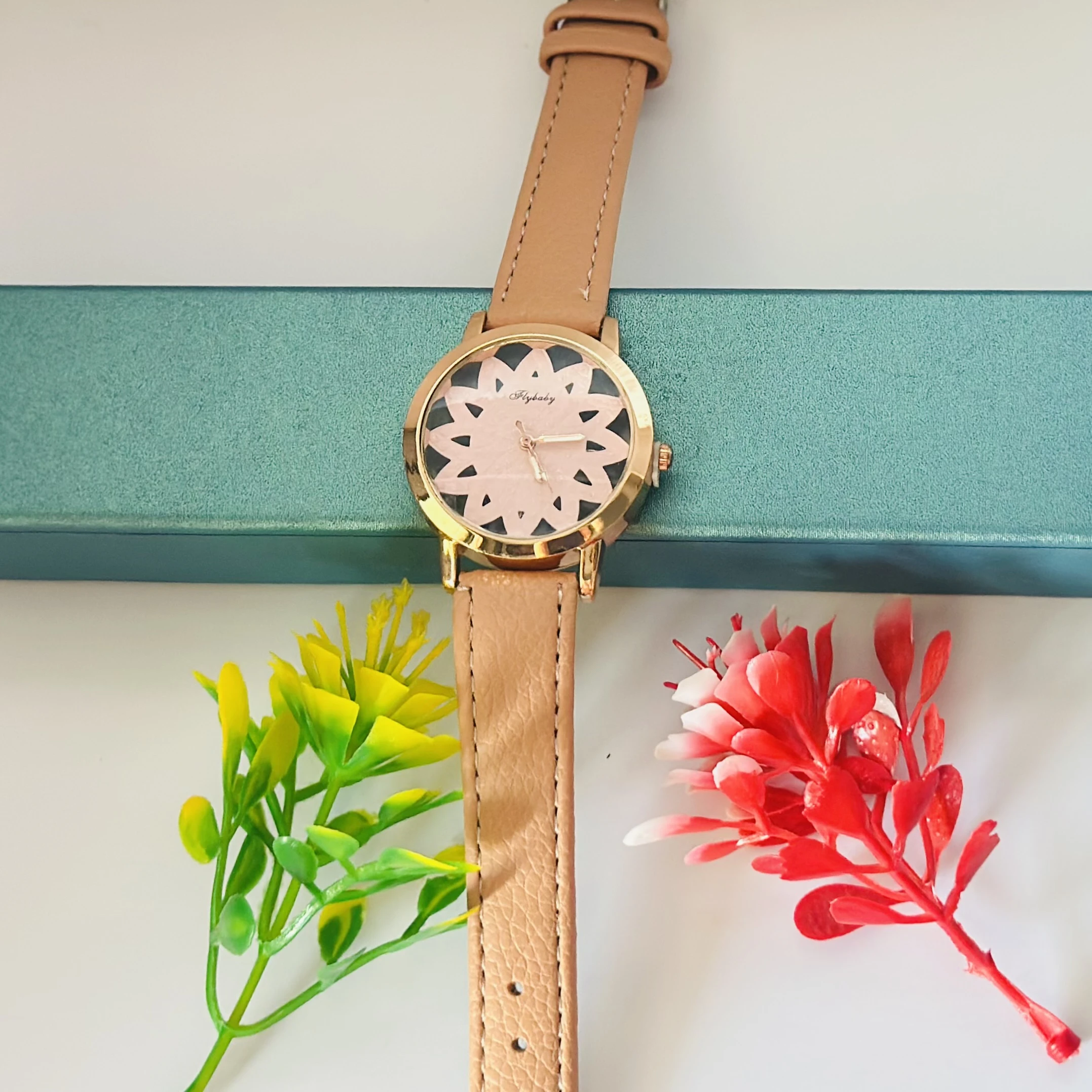 Flybaby flower watch with a peach/tan faux leather strap.