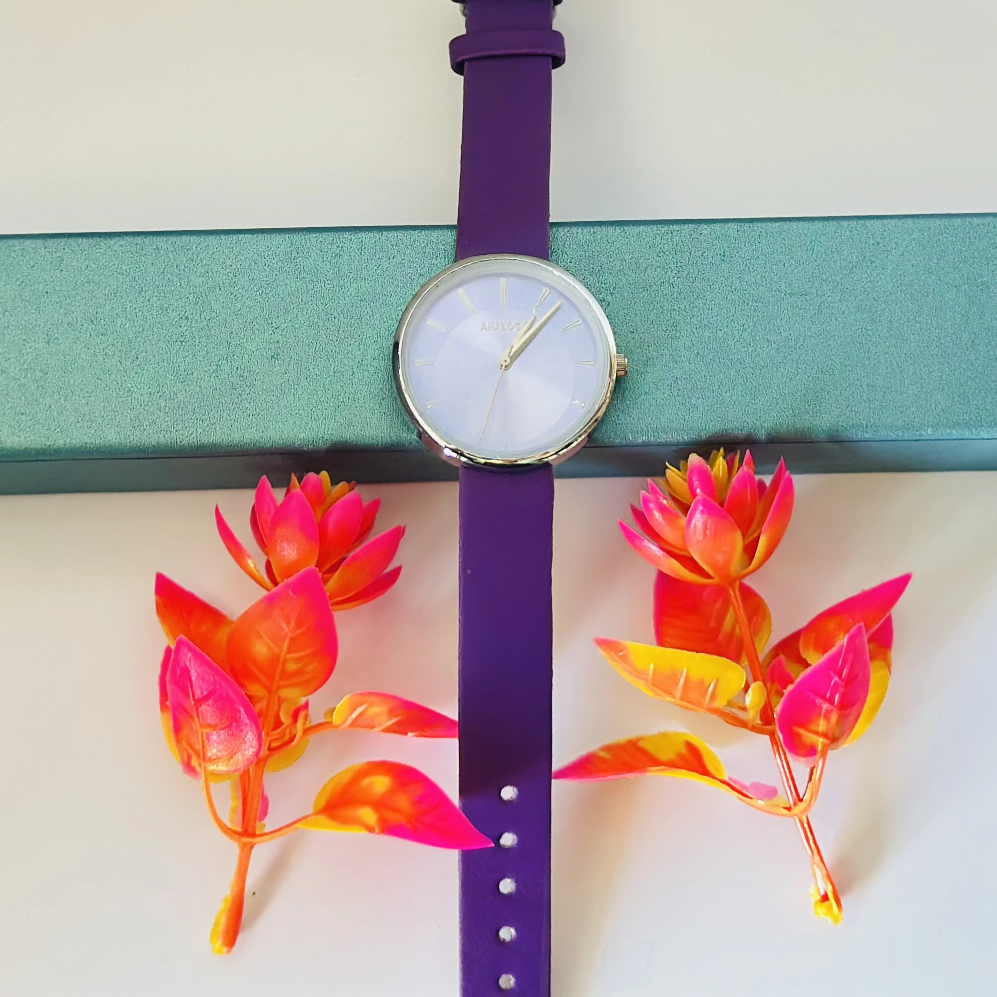 purple analog watch with a black leather strap.