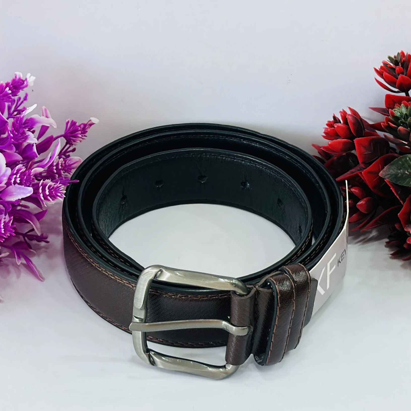 Brown leather belt with a pin buckle.