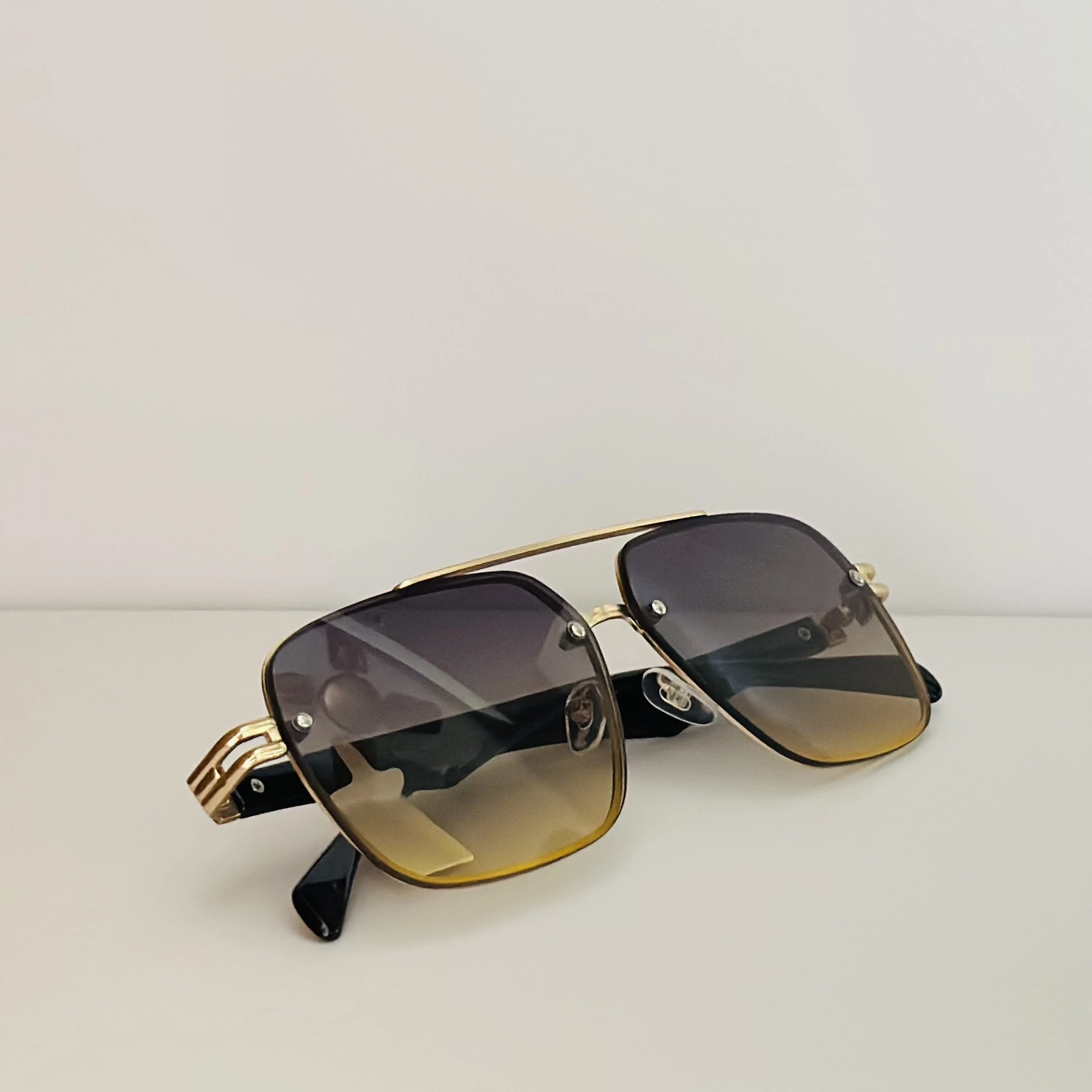 square aviator sunglasses with a gold-toned metal frame and brown gradient lenses
