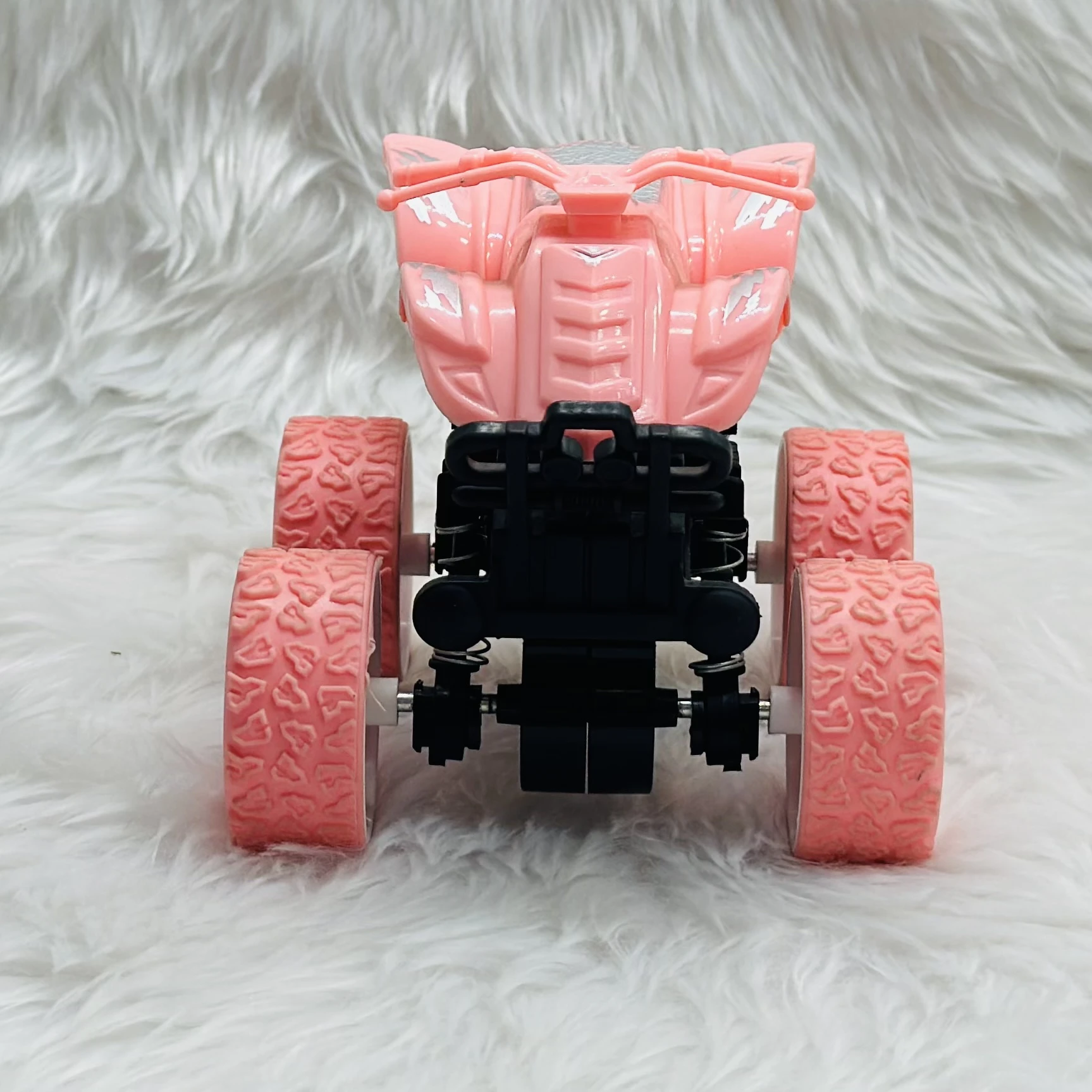 pink toy monster truck, specifically a friction-powered, four-wheel-drive inertia car.