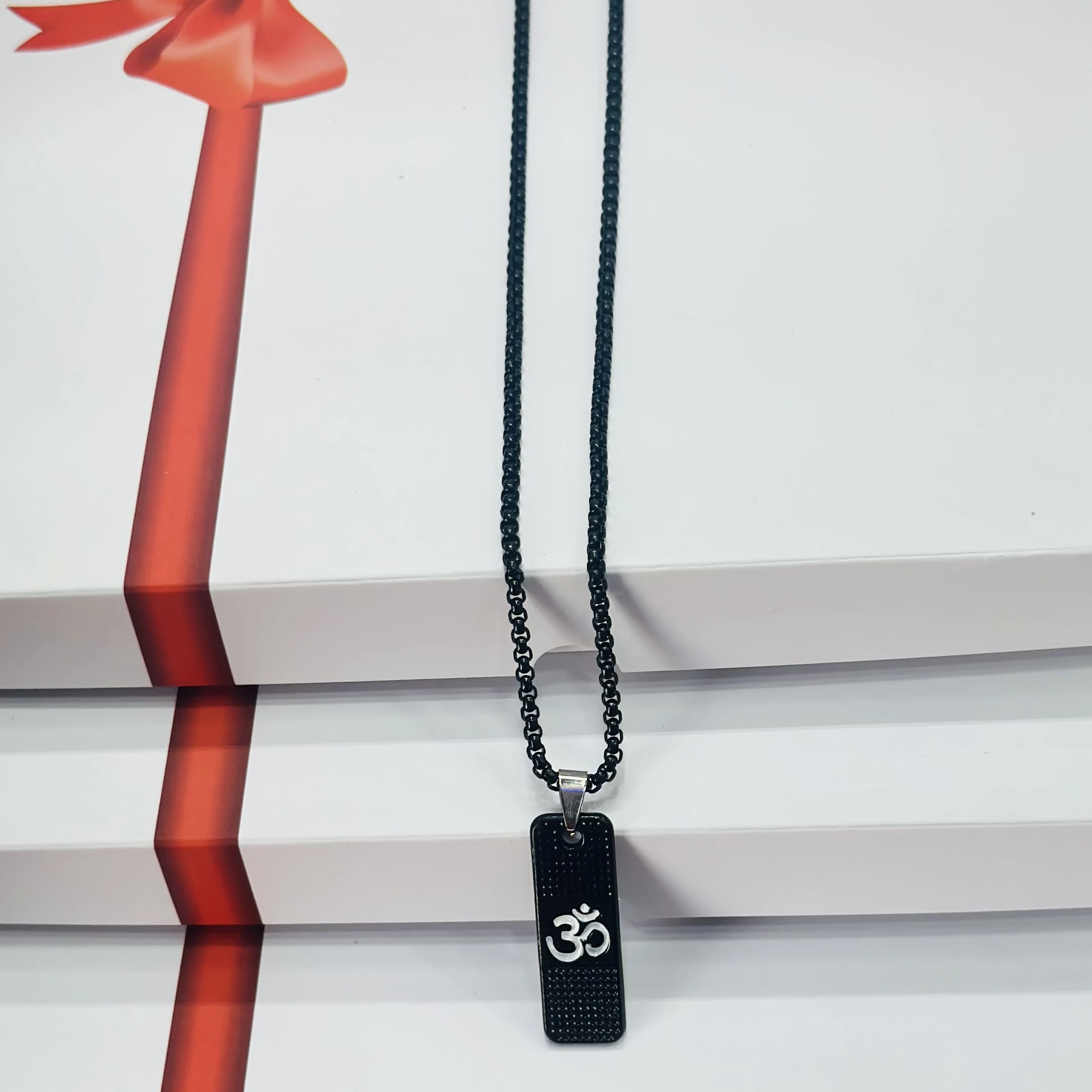 Black stainless steel pendant necklace with the white Om symbol.