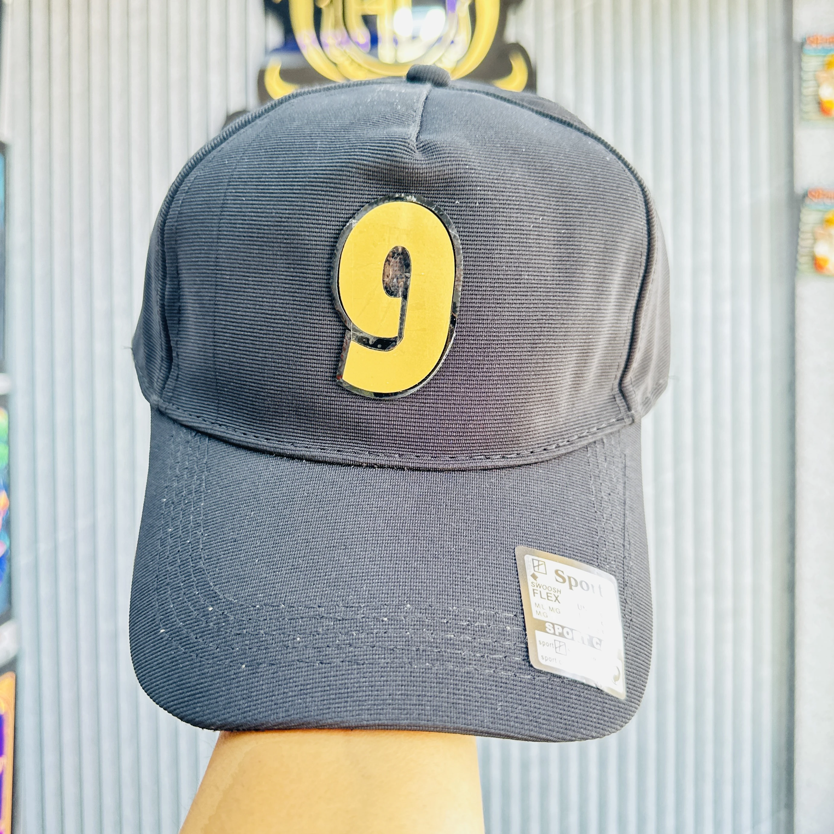 cap features a prominent yellow and black number '9' patch on the front.
