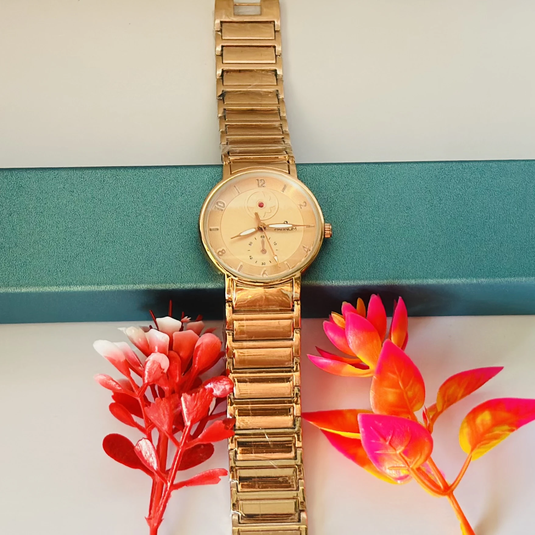 Gold -tone women's analog watch with a metal link bracelet.
