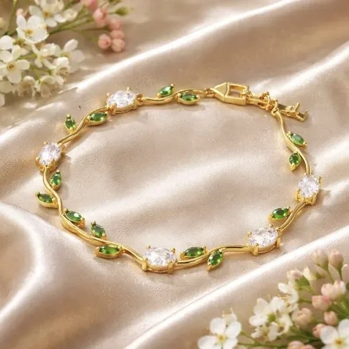 gold plated tulip bracelet featuring white oval crystals and green marquise leaf accents