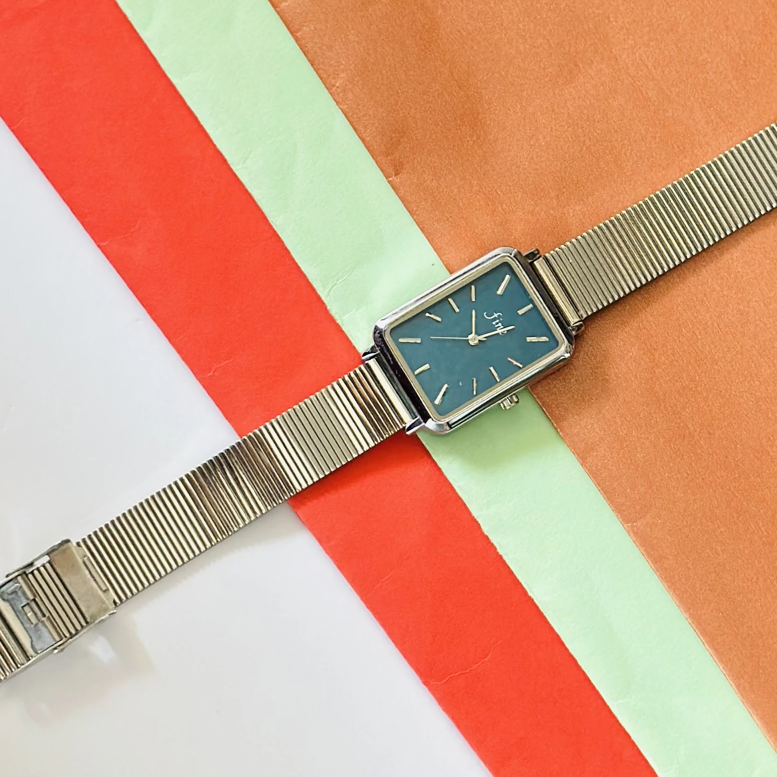 Rectangular Dial analog watch with a mesh strap.