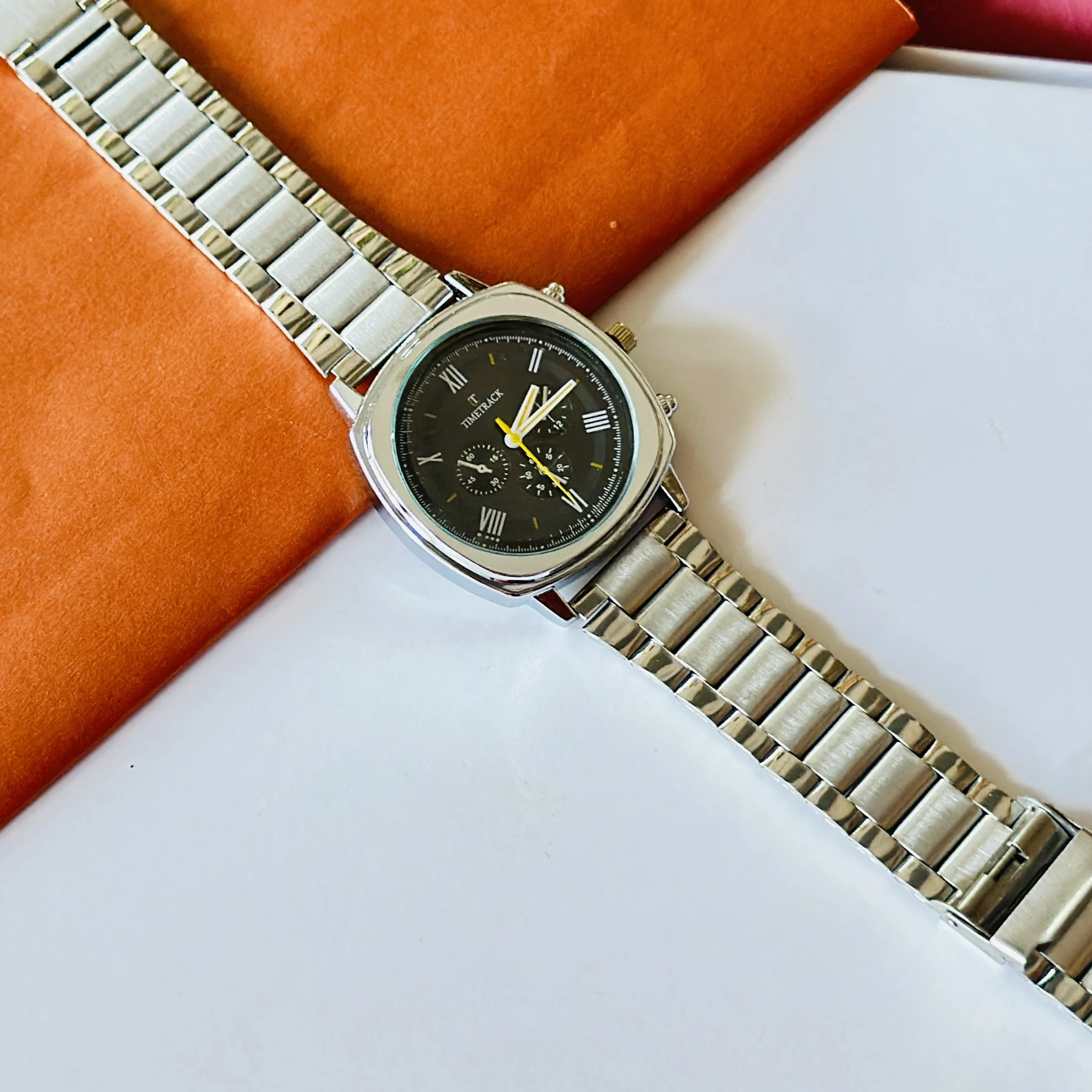 Timetrack brand analog watch with a square case and a stainless steel strap.
