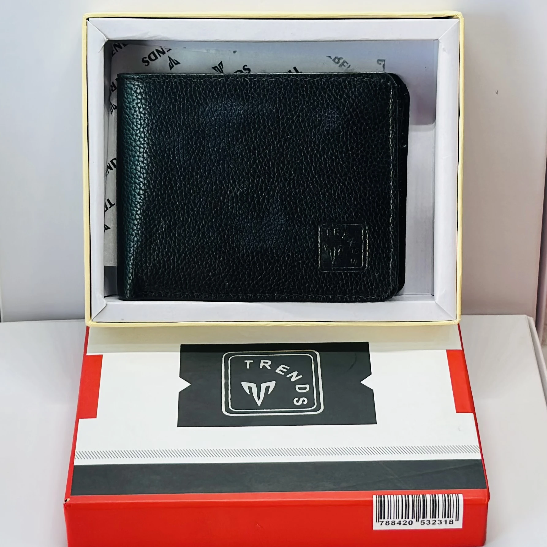 Black leather bifold wallet with a "Trends" logo.
