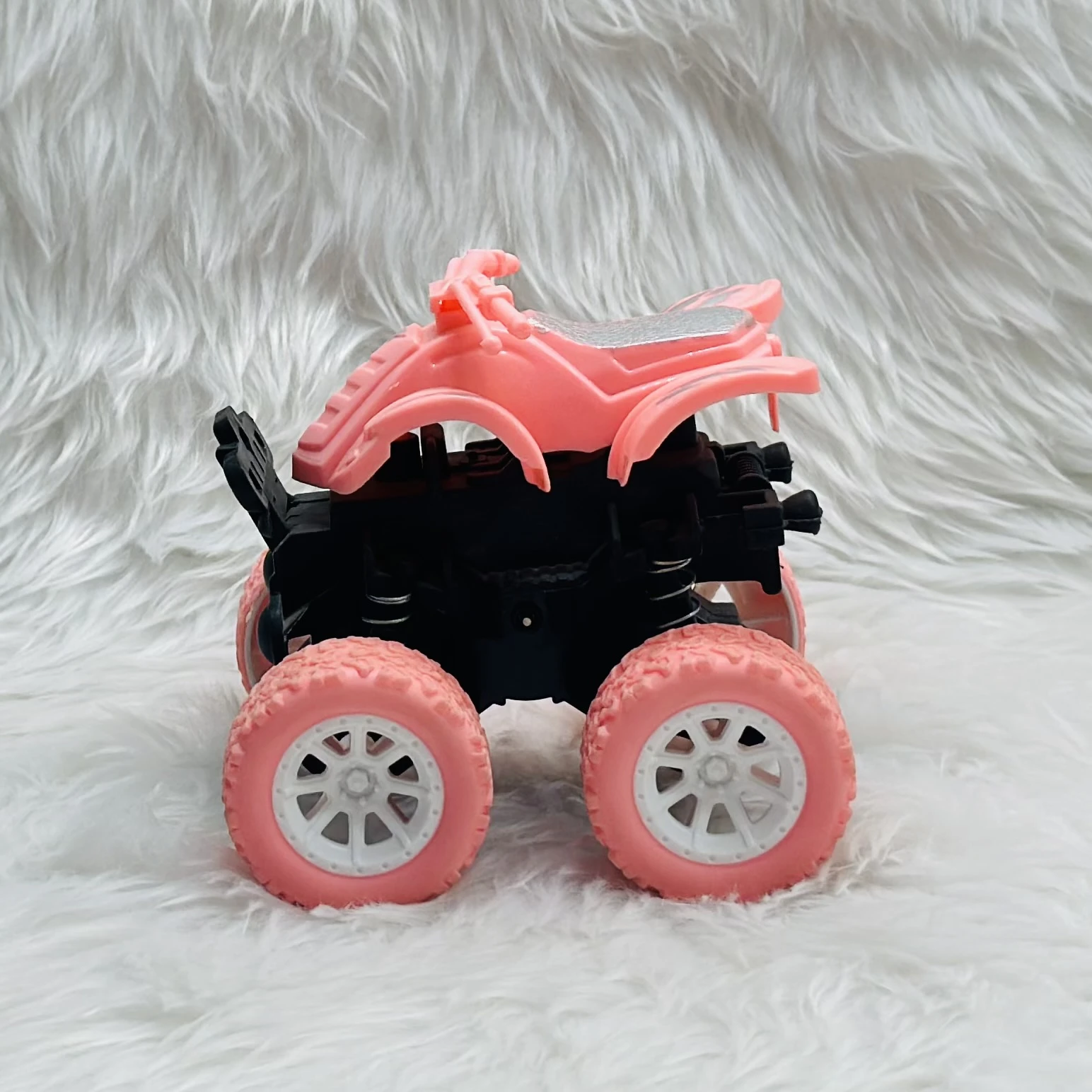 pink toy monster truck, specifically a friction-powered, four-wheel-drive inertia car.
