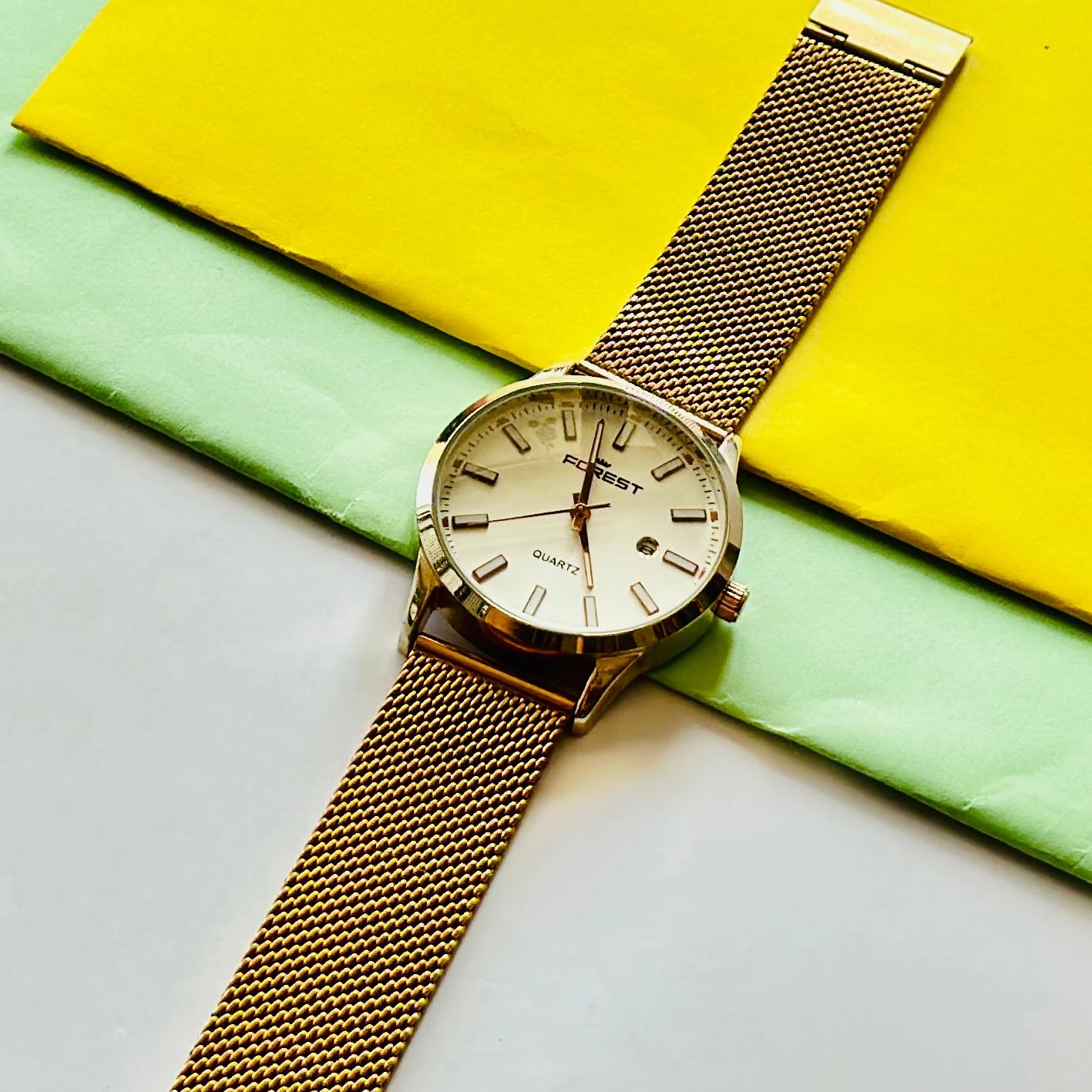 Forest quartz analog watch with a gold-tone mesh strap and a white dial.