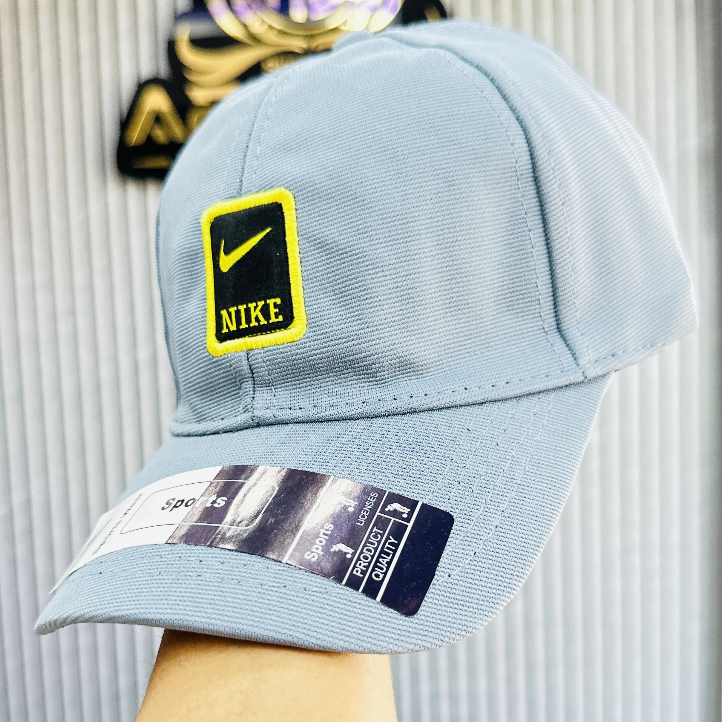 Blue Nike baseball cap featuring a yellow and black logo patch on the front.