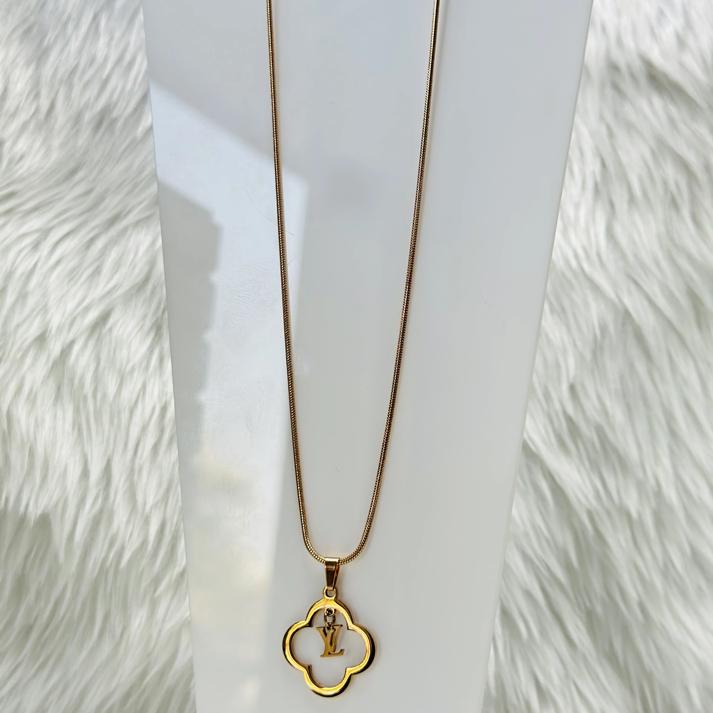 gold-plated pendant with a quatrefoil pendant featuring the 'LV' logo