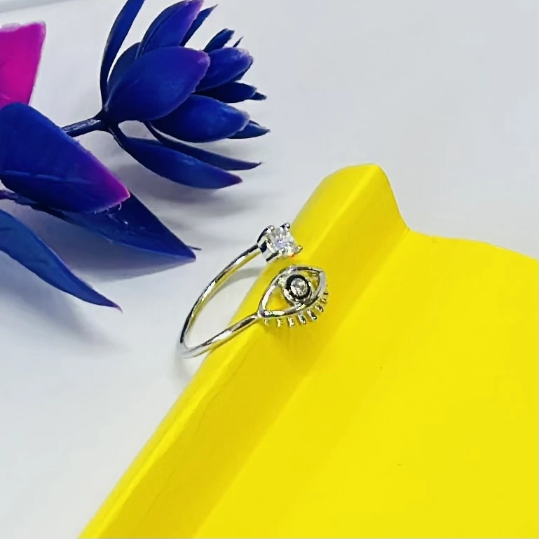 an adjustable sterling silver "evil eye" ring with a clear cubic zirconia stone.