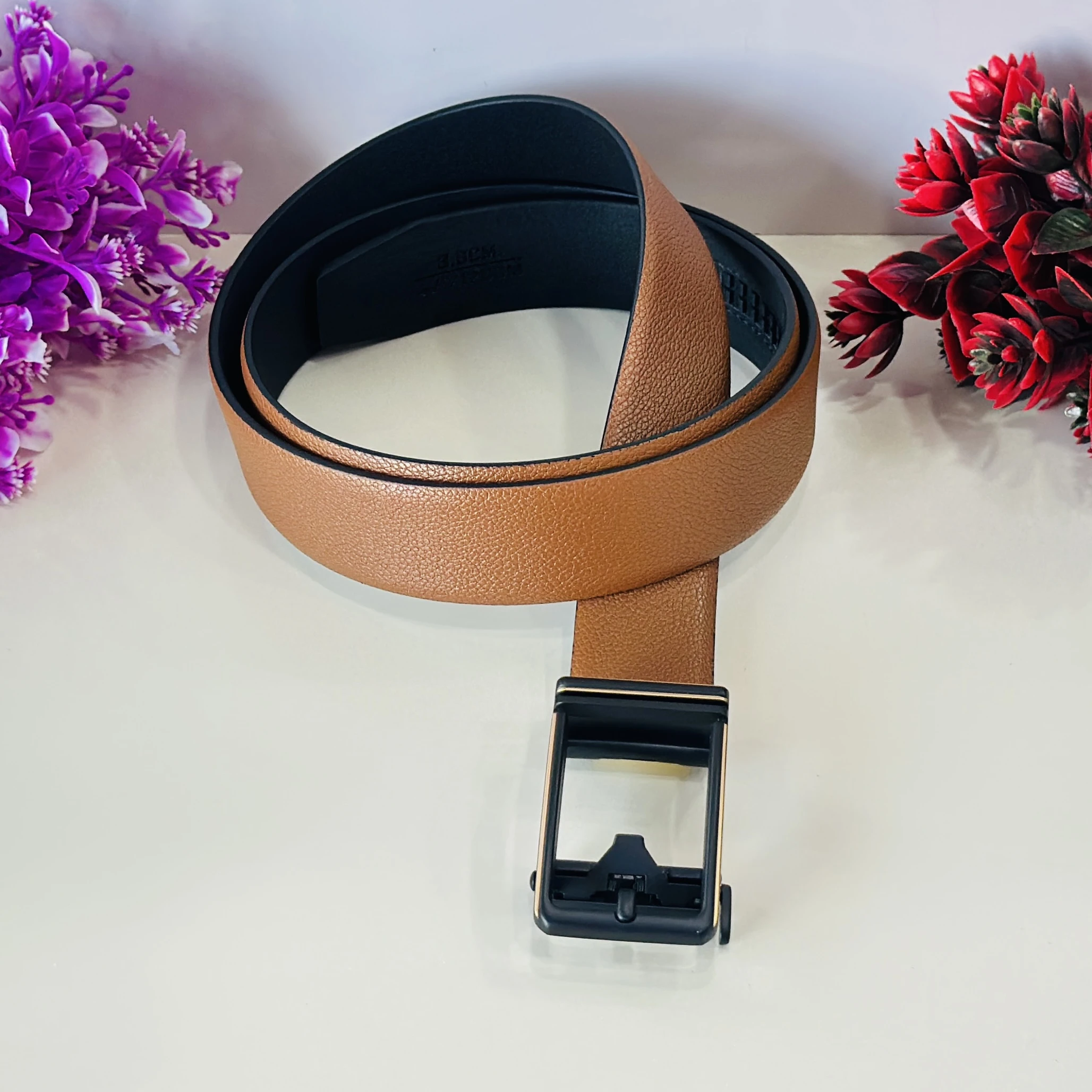 Tan and black reversible formal belt with an auto-lock buckle.