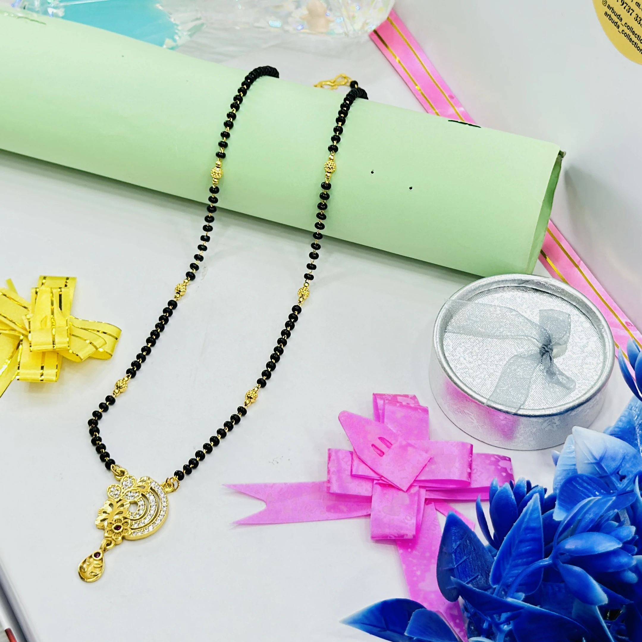 gold-plated mangalsutra features a designer pendant and black beaded chain.
