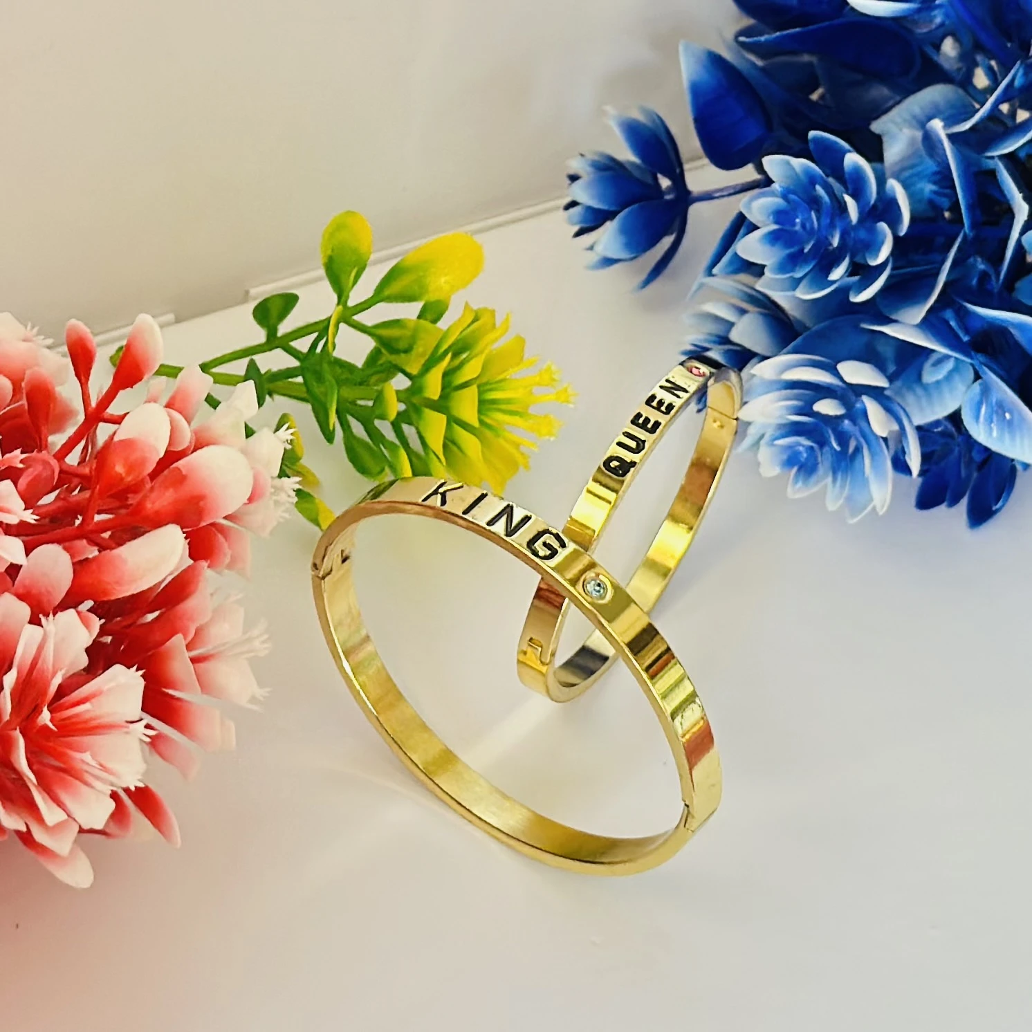 Gold plated "Queen" cuff bracelet with a pink stone accent.