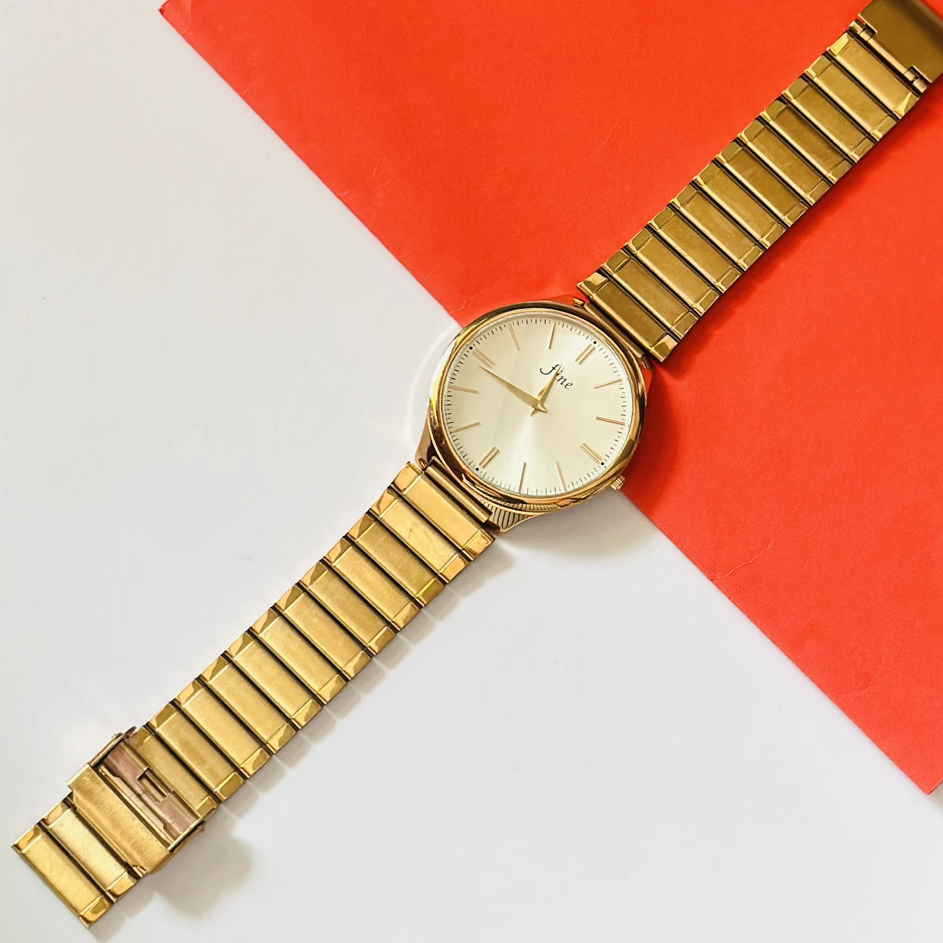 Gold toned analog watch with a stainless steel strap