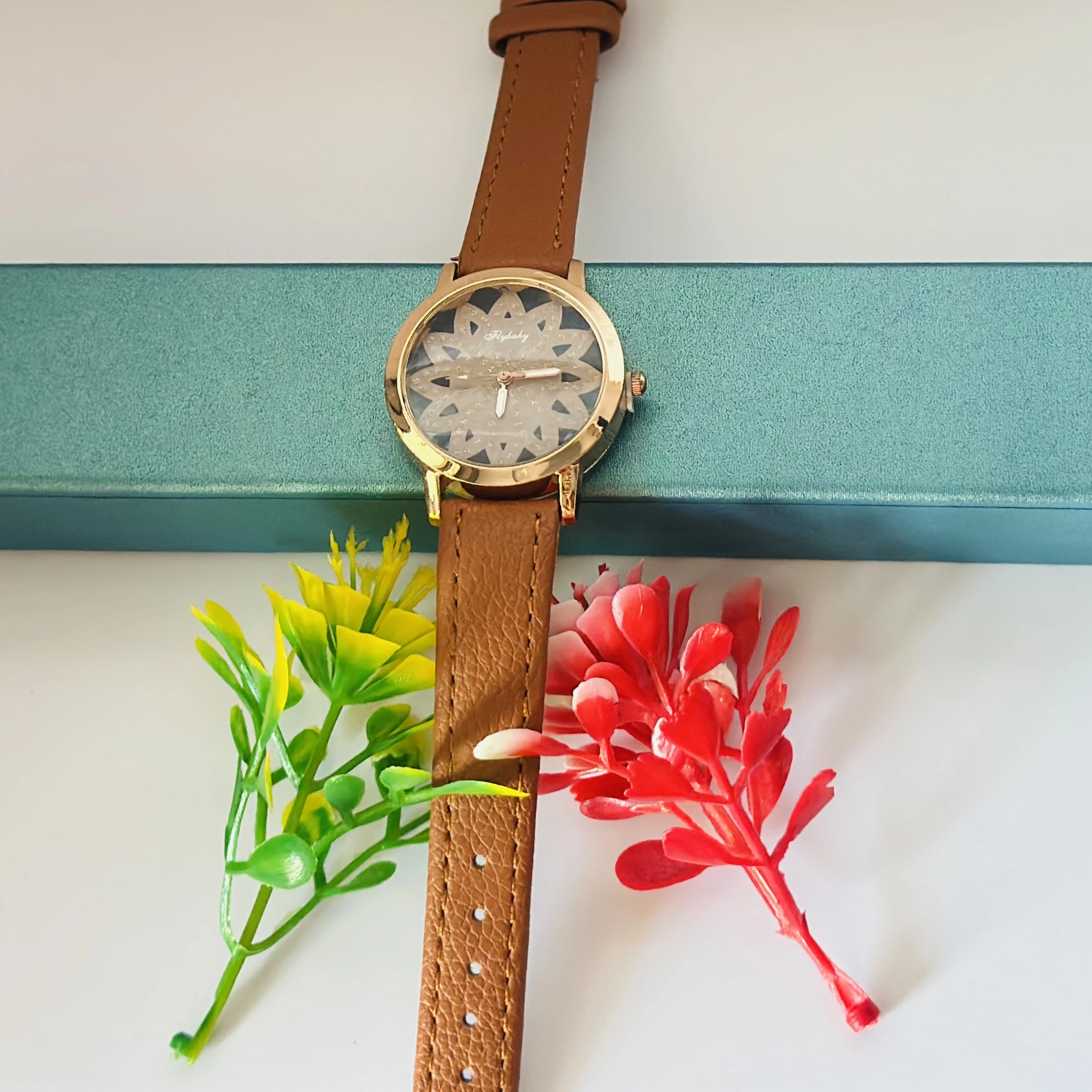 Flybaby flower watch with a peach/tan faux leather strap.
