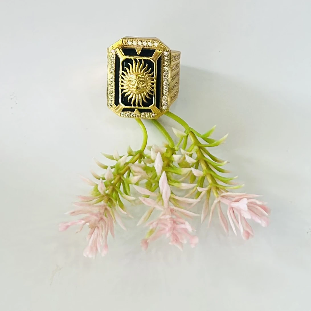 Gold plated men's ring featuring a sun emblem on a black background